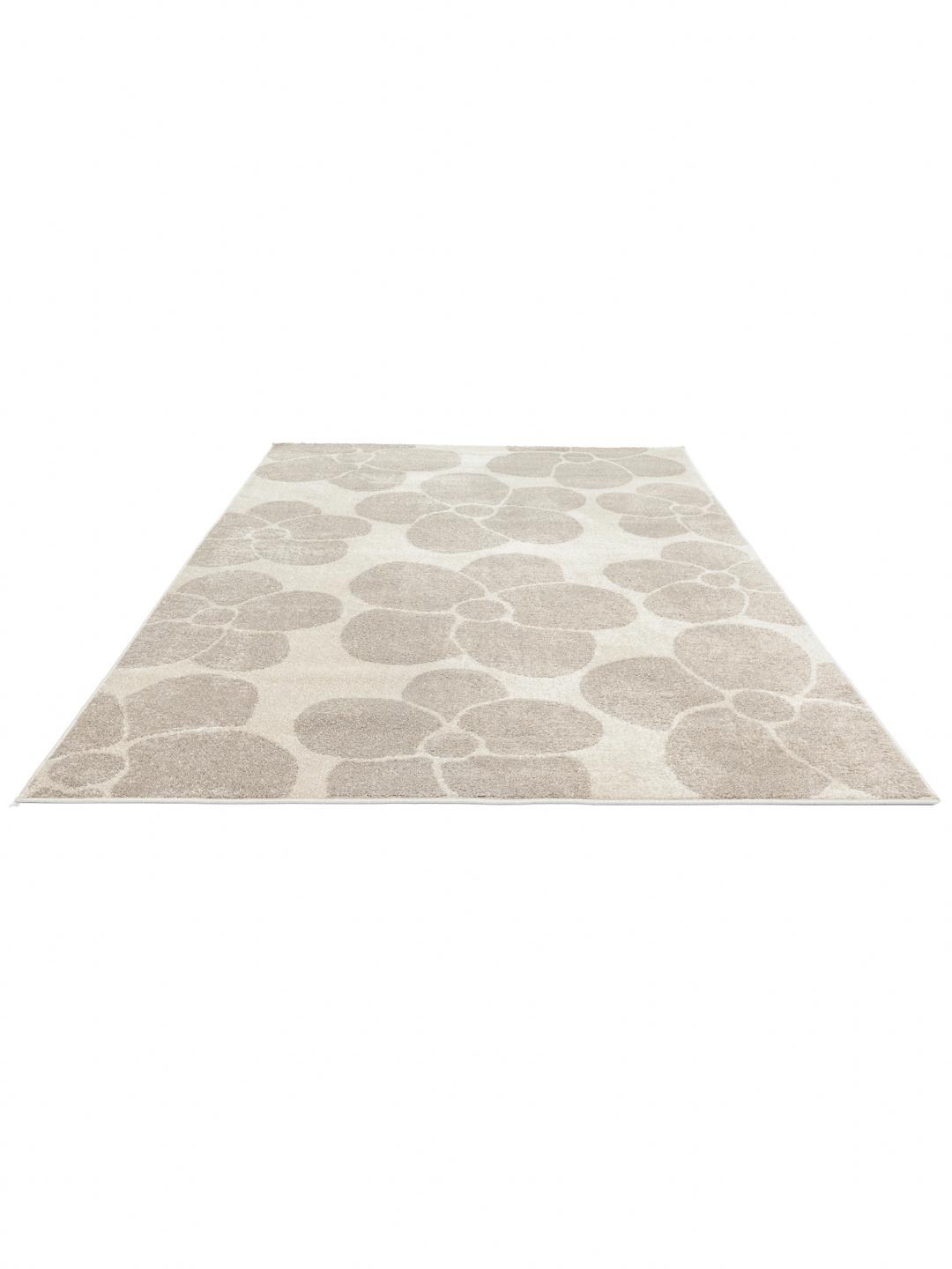 Un tapis floral beige et blanc cassé avec une texture de poil doux.