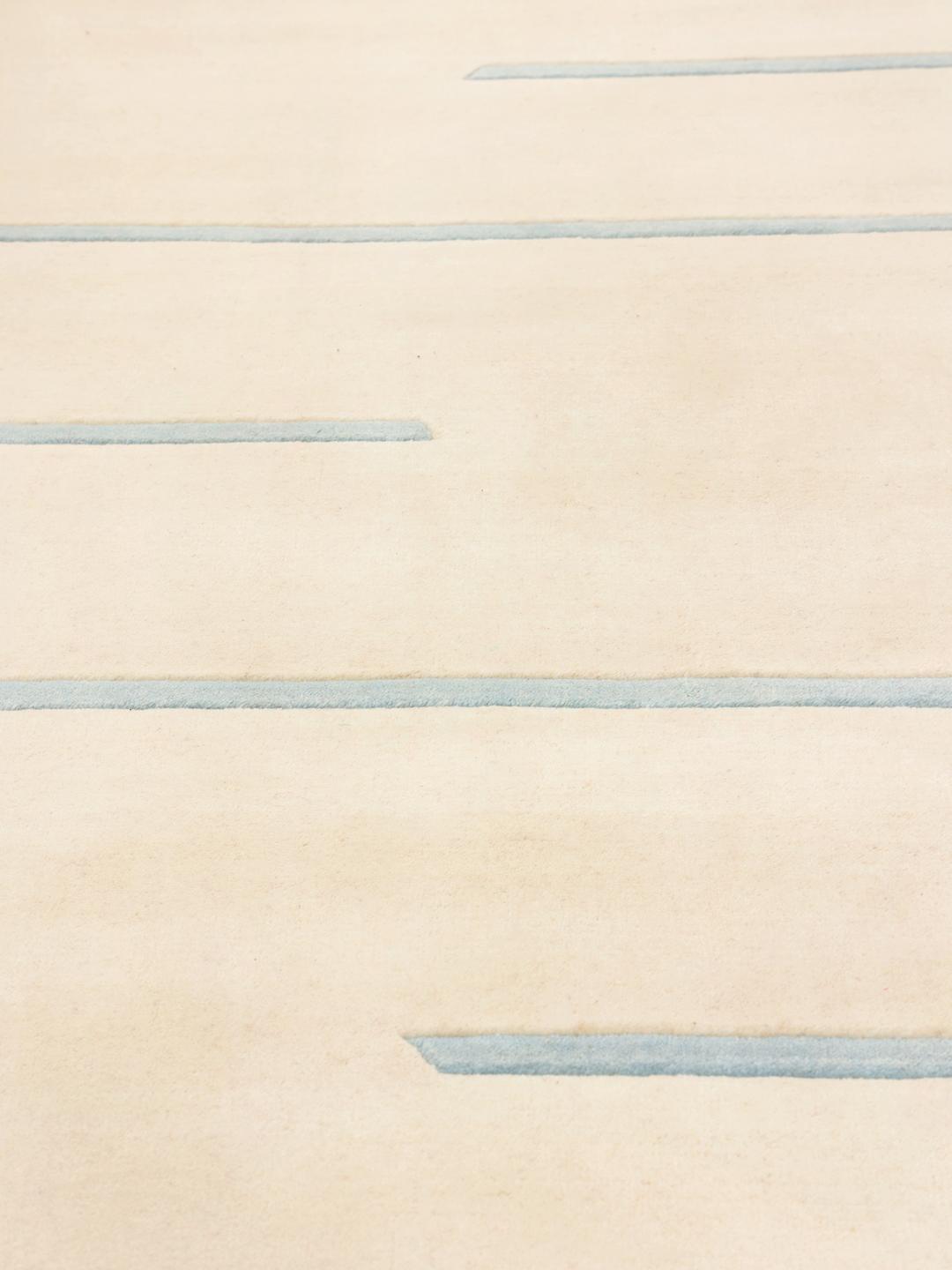 Et moderne beige og lyseblåt tæppe med et minimalistisk design af vandrette linjer fra Indien