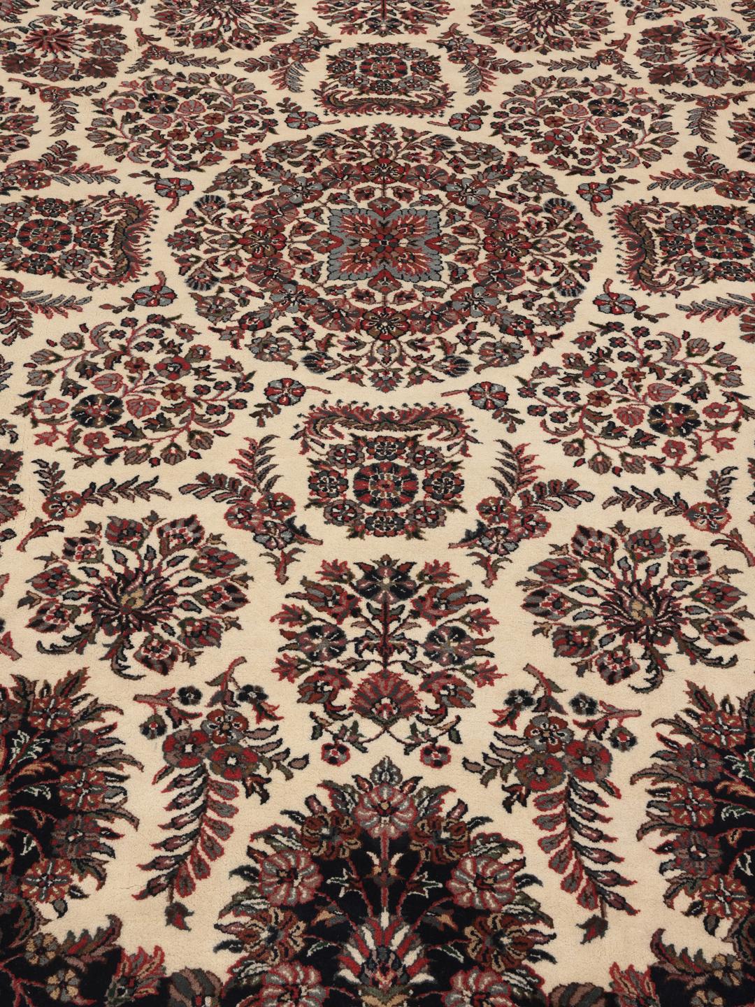 Een rond beige en donkerrood handgeknoopt Sarouk tapijt uit India