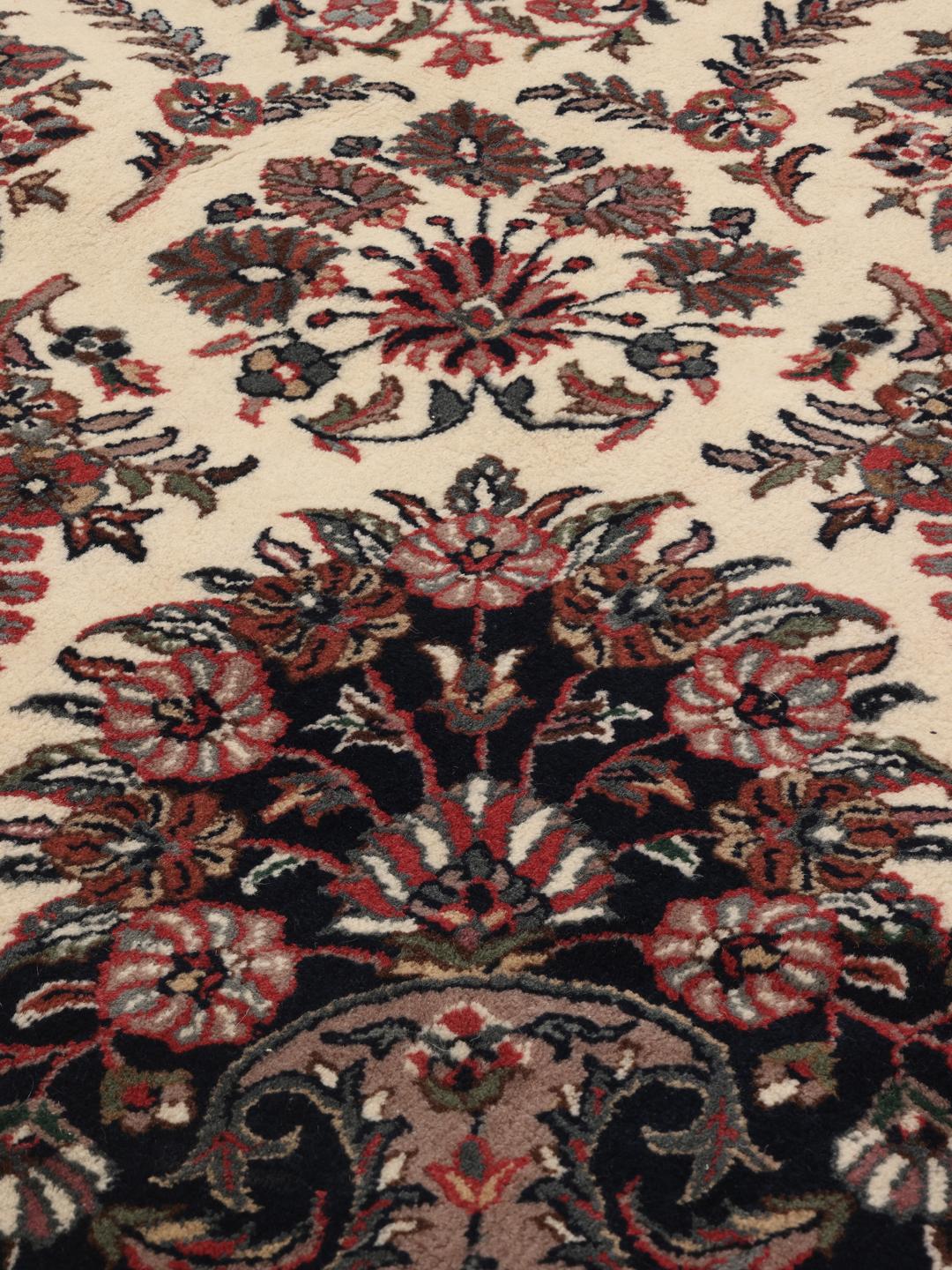 Een rond beige en donkerrood handgeknoopt Sarouk tapijt uit India