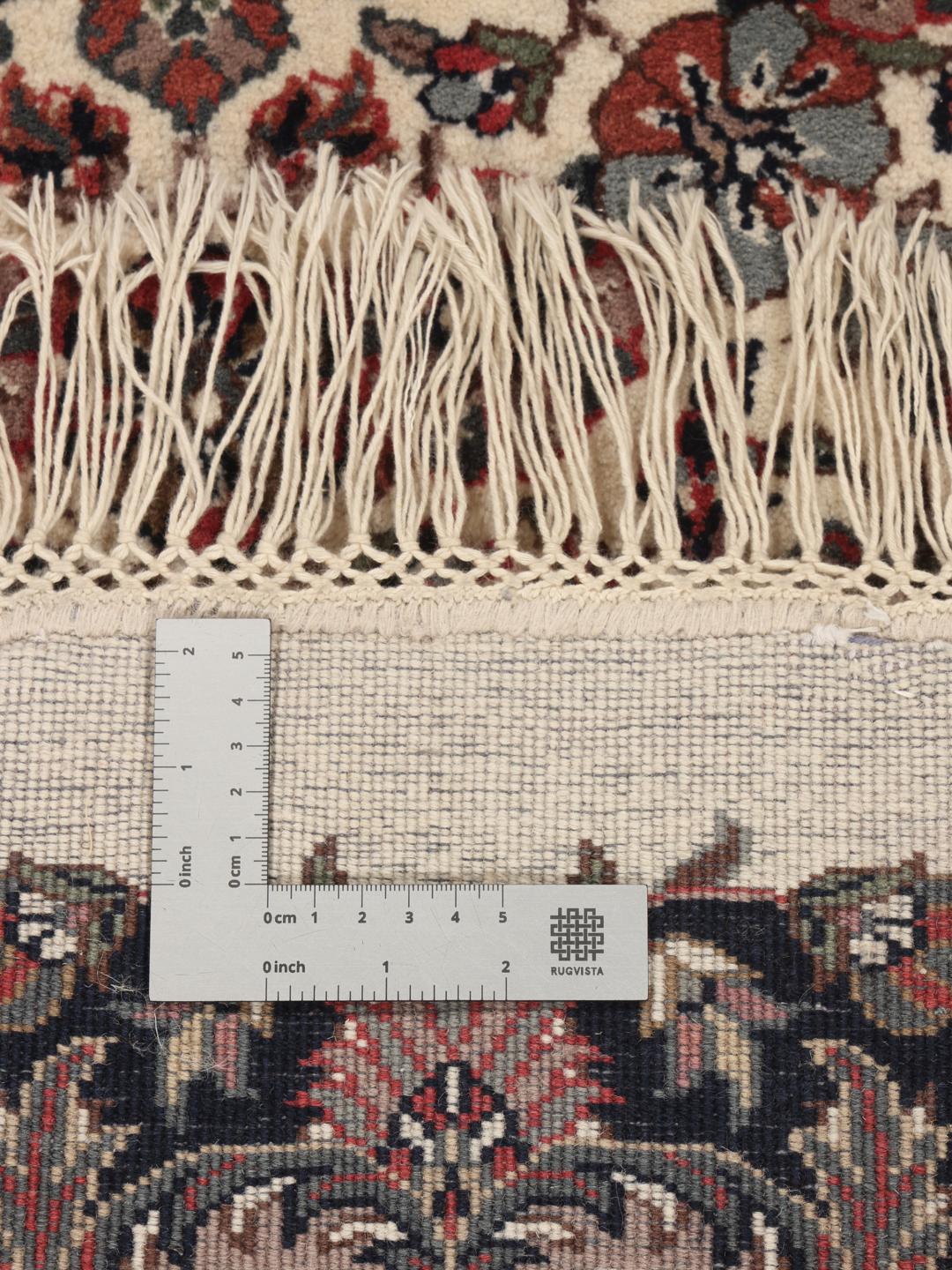 Een rond beige en donkerrood handgeknoopt Sarouk tapijt uit India