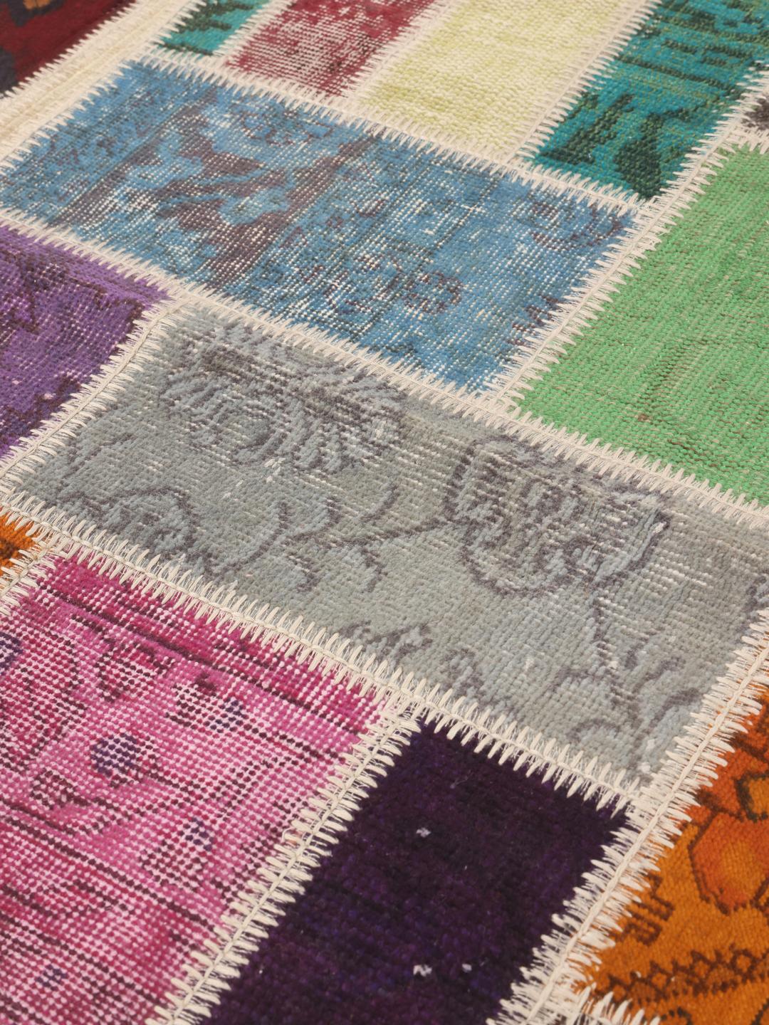 Et rektangulært patchwork-teppe fra Tyrkia med et levende flerfarget design.