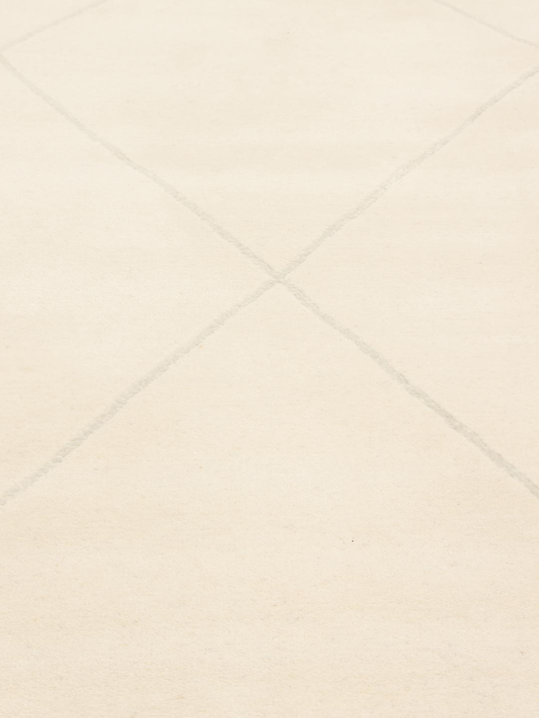Un tapis moderne fabriqué à la main en Inde avec un motif délicat en losanges beige.