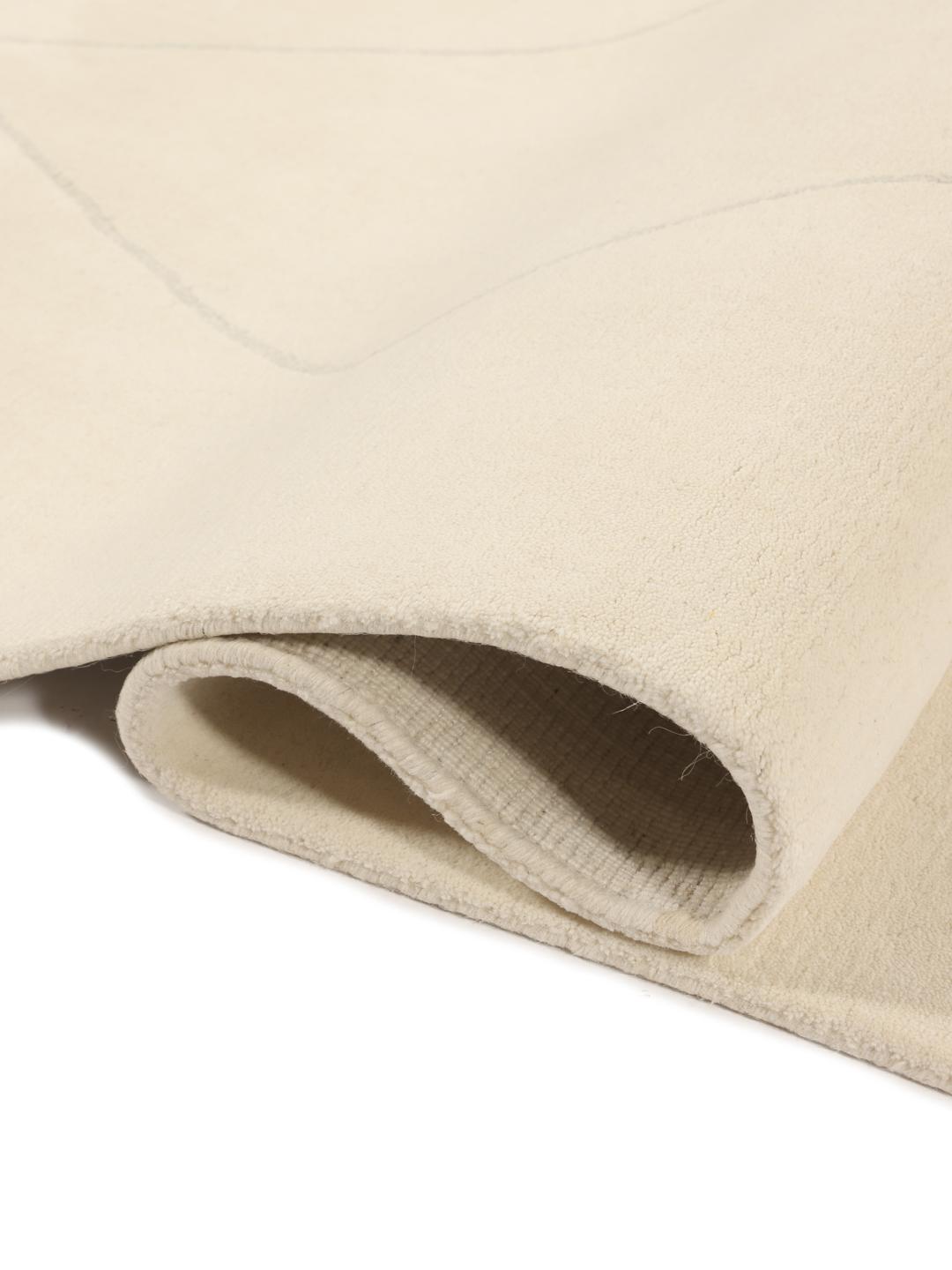 Un tapis moderne fabriqué à la main en Inde avec un motif délicat en losanges beige.
