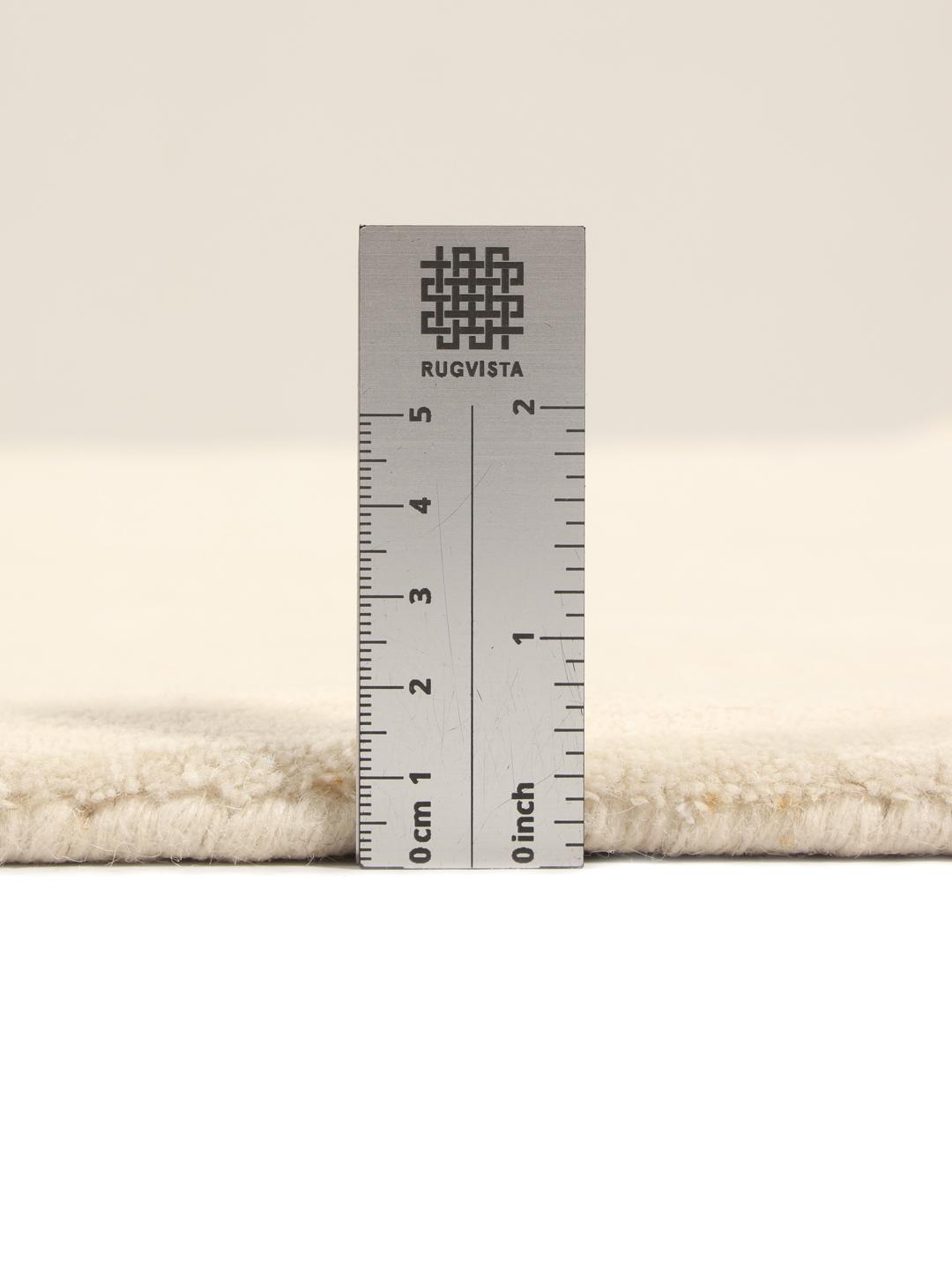 Un tapis moderne fabriqué à la main en Inde avec un motif délicat en losanges beige.
