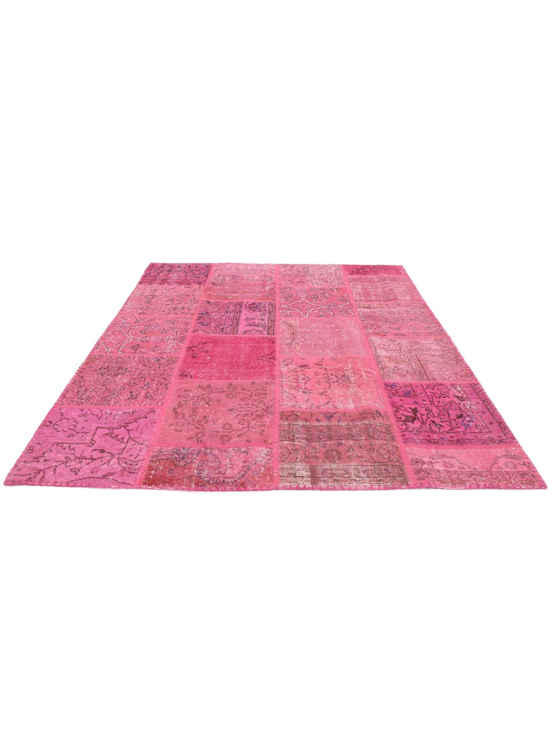 Et levende rosa tyrkisk patchwork-teppe med en rekke tradisjonelle mønstrede fragmenter.