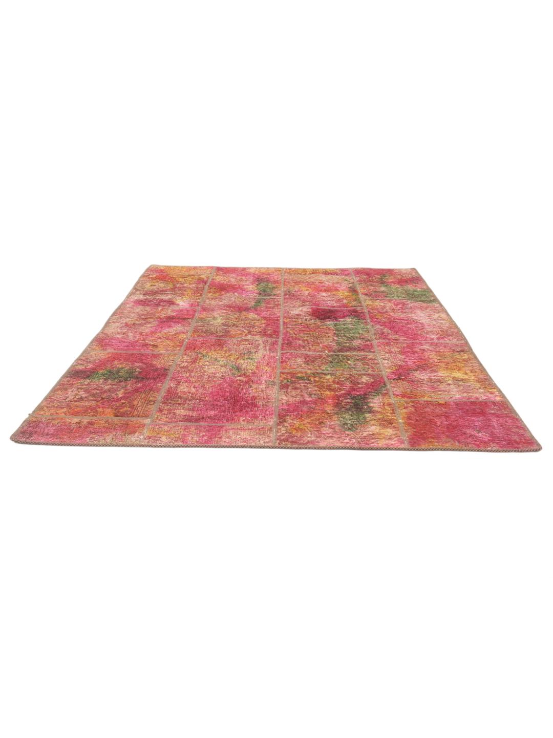 Un tapis patchwork vibrant présentant un mélange de couleurs rouge, jaune et verte provenant du Moyen-Orient