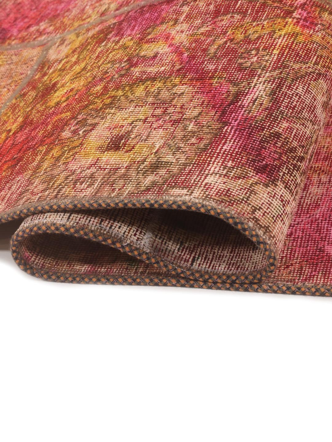 Un tapis patchwork vibrant présentant un mélange de couleurs rouge, jaune et verte provenant du Moyen-Orient