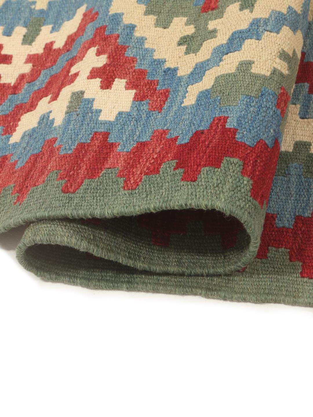 Et stort rektangulært håndvævet Kilim Ghashghai tæppe fra Mellemøsten med et flerfarvet geometrisk mønster.