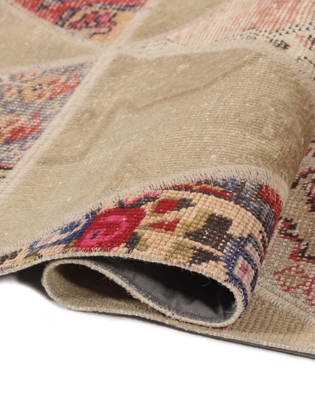 Een uniek Turks patchwork tapijt met een geometrisch driehoekspatroon in veelkleurige wol.