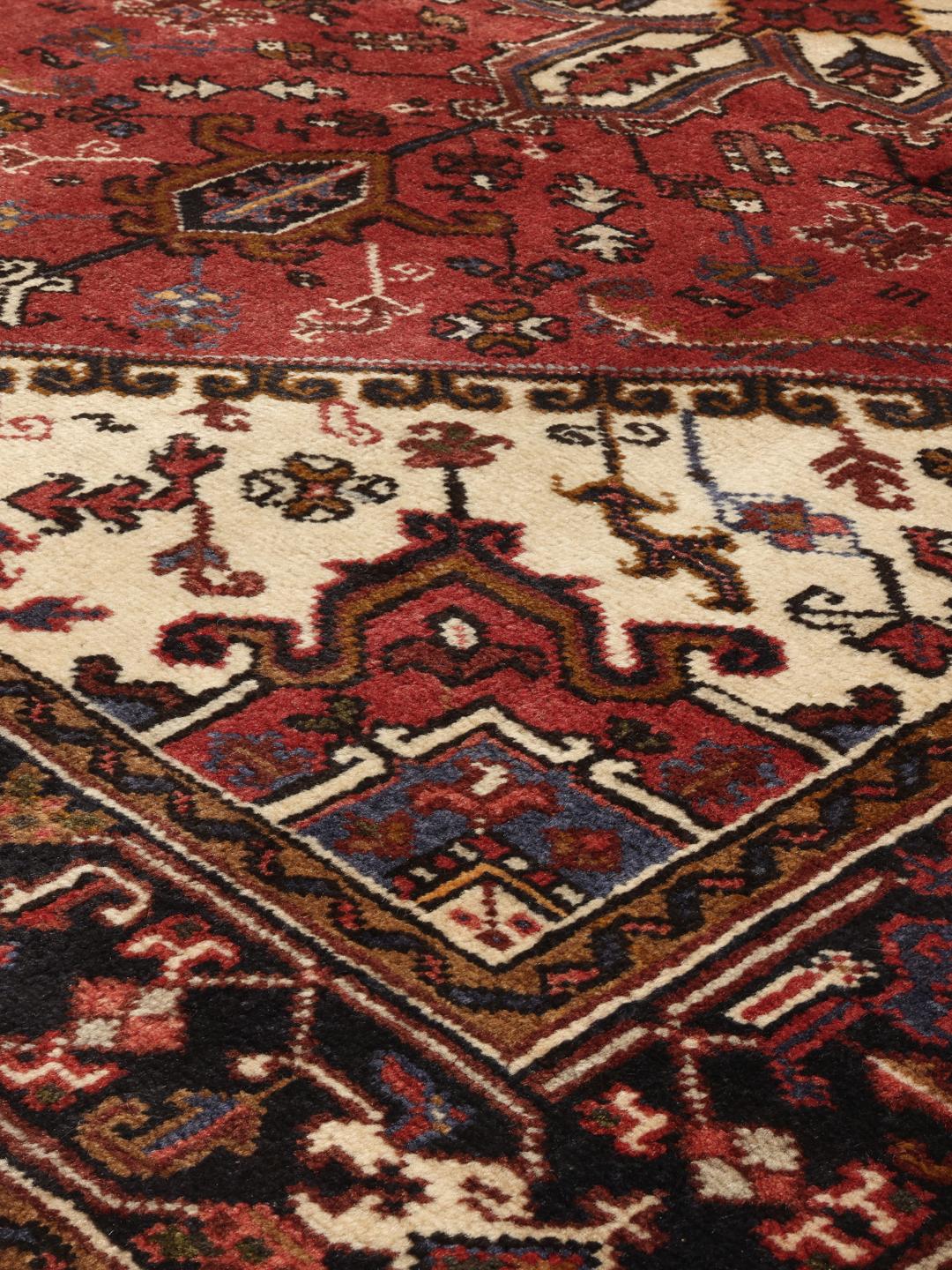 Un tapis Mehraban noué à la main provenant du Moyen-Orient, arborant un motif géométrique audacieux dans des tons de rouge et de beige.