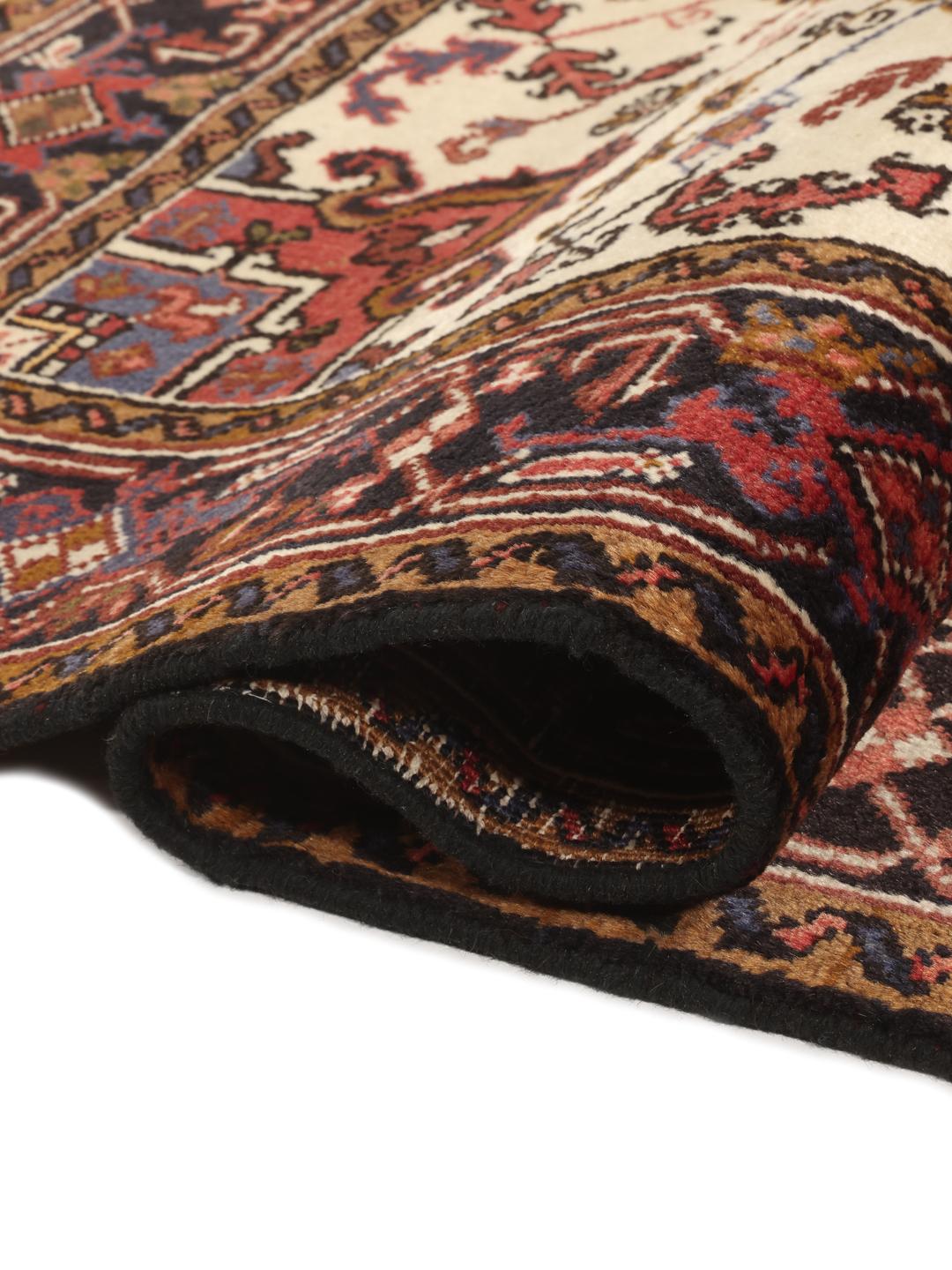 Un tapis Mehraban noué à la main provenant du Moyen-Orient, arborant un motif géométrique audacieux dans des tons de rouge et de beige.