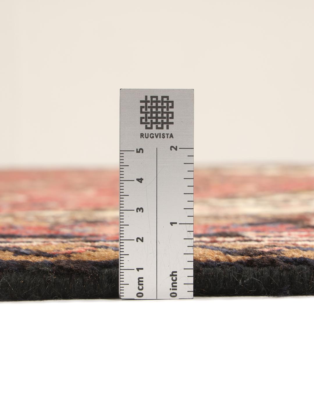 Un tapis Mehraban noué à la main provenant du Moyen-Orient, arborant un motif géométrique audacieux dans des tons de rouge et de beige.
