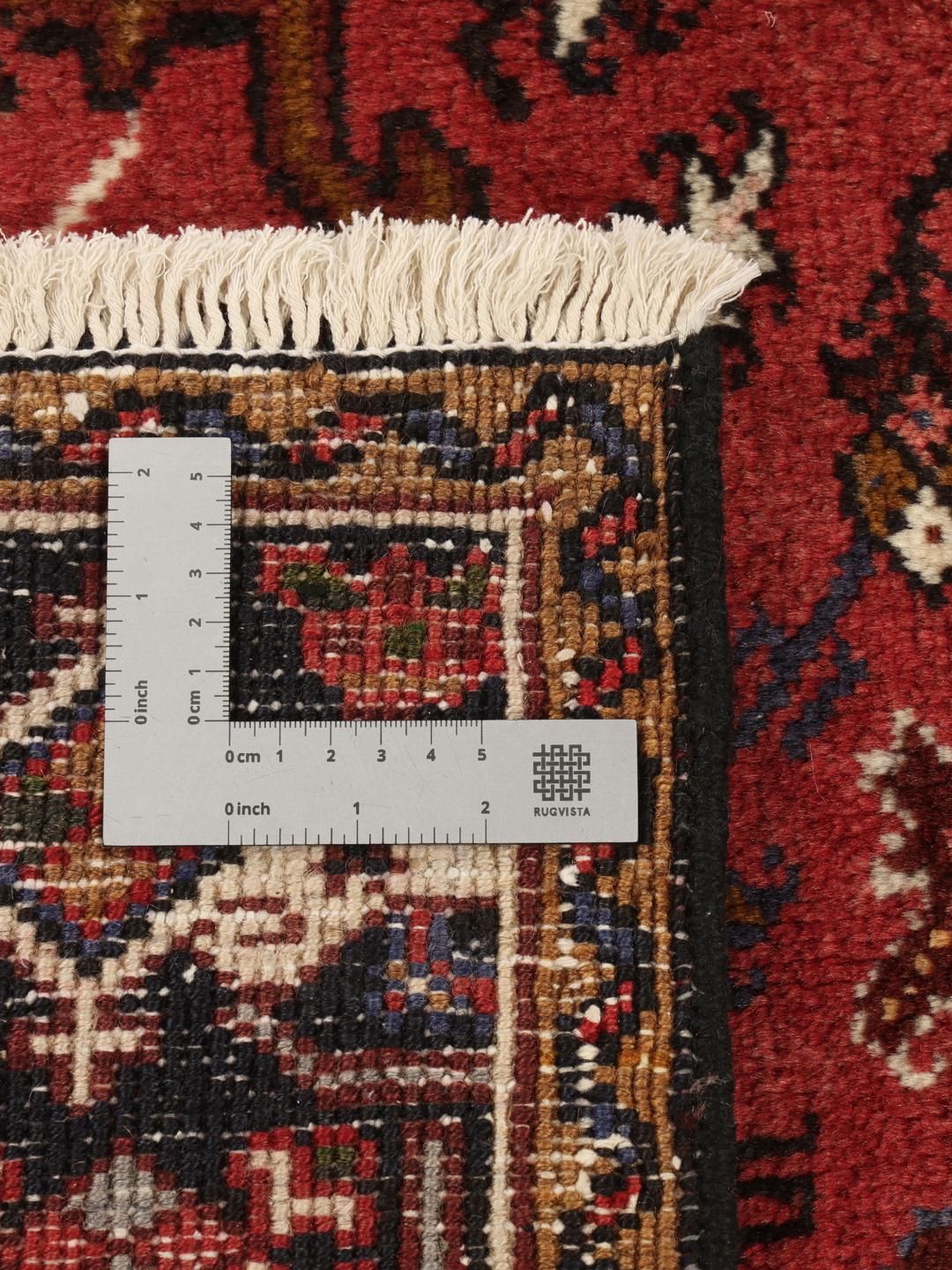Un tapis Mehraban noué à la main provenant du Moyen-Orient, arborant un motif géométrique audacieux dans des tons de rouge et de beige.