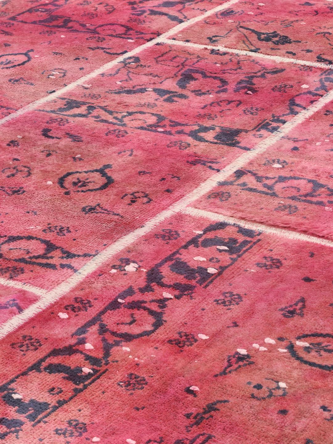 A vibrant dark-pink patchwork rug with Middle Eastern inspired motifs