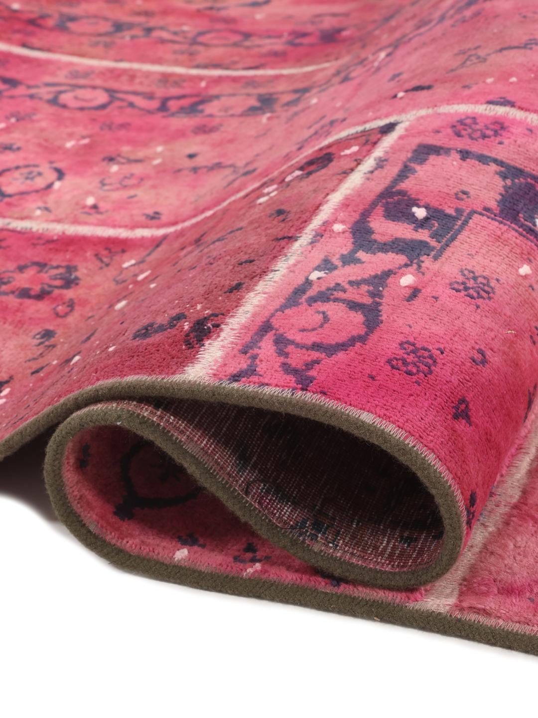 A vibrant dark-pink patchwork rug with Middle Eastern inspired motifs