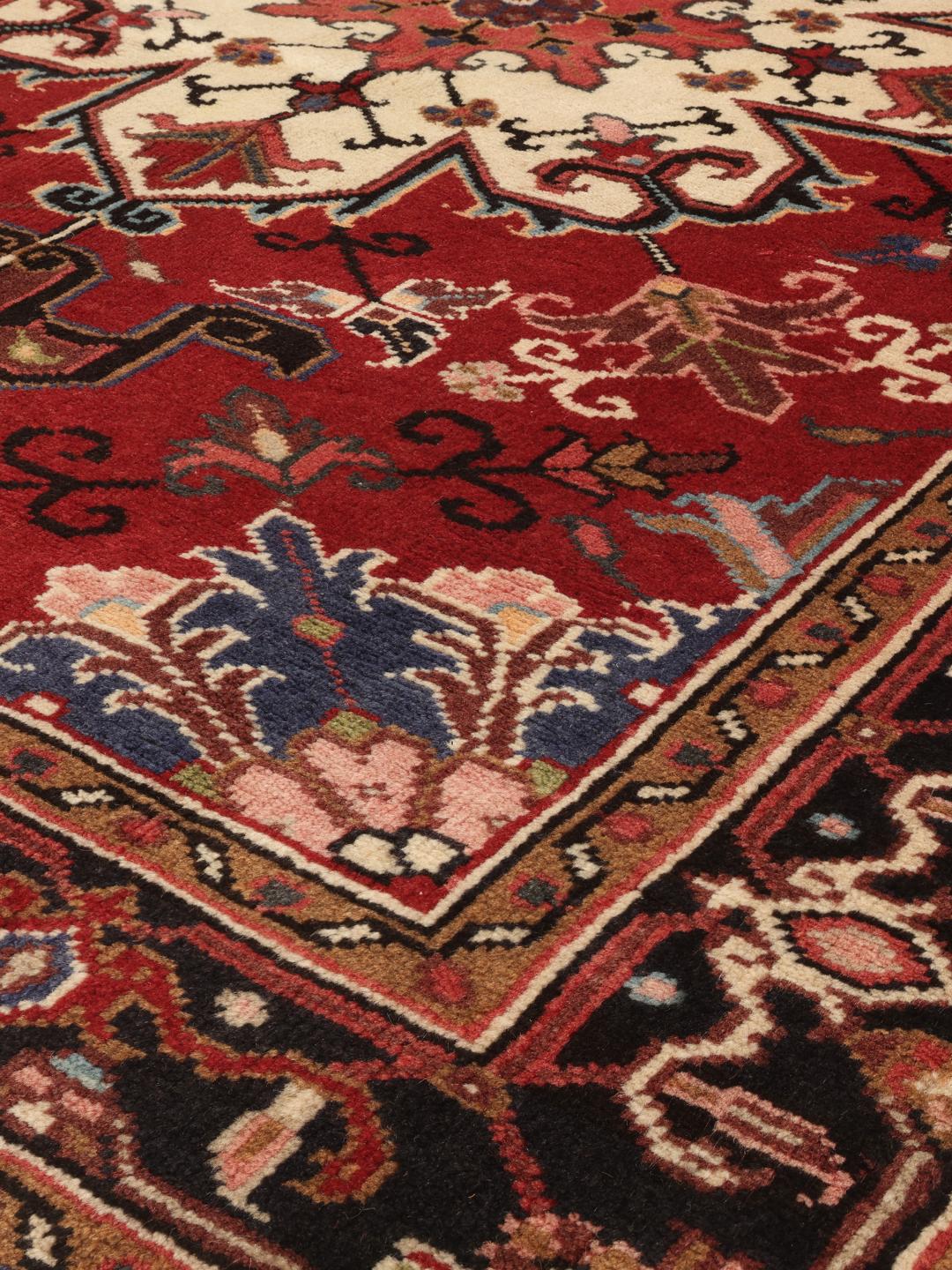 Tapis Mehraban noué à la main provenant du Moyen-Orient, présentant un champ rouge et un médaillon crème.
