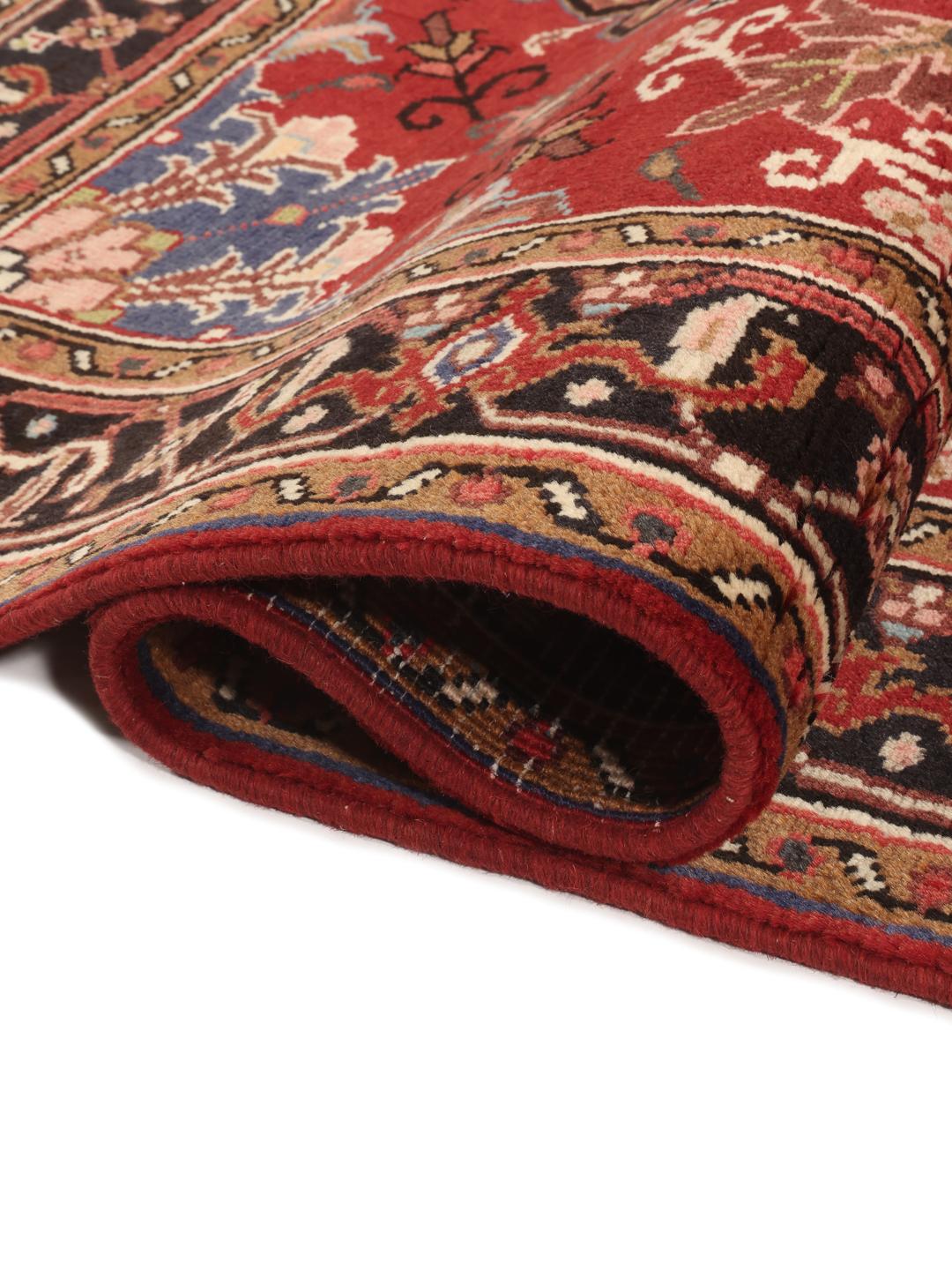 Tapis Mehraban noué à la main provenant du Moyen-Orient, présentant un champ rouge et un médaillon crème.
