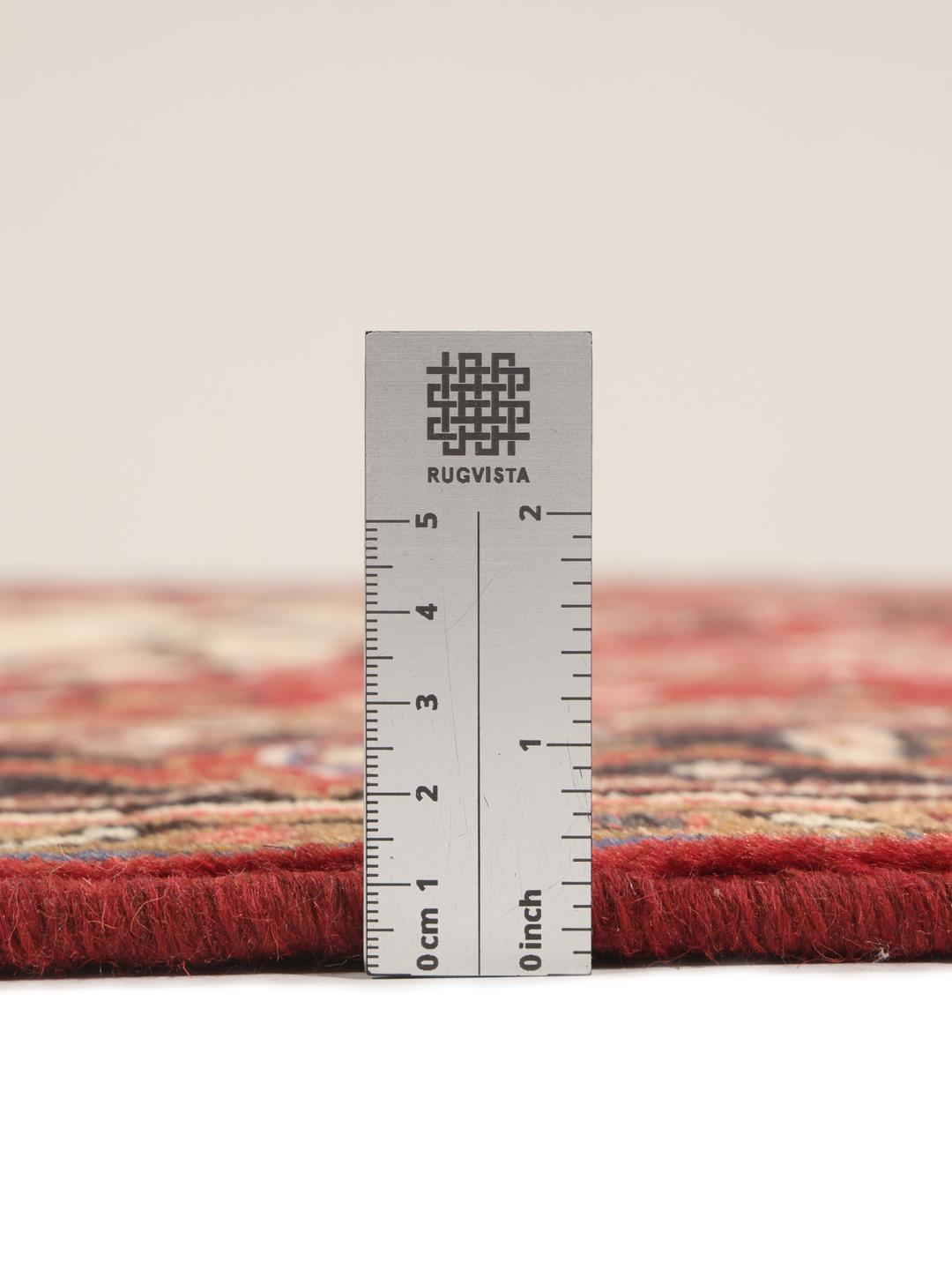 Tapis Mehraban noué à la main provenant du Moyen-Orient, présentant un champ rouge et un médaillon crème.