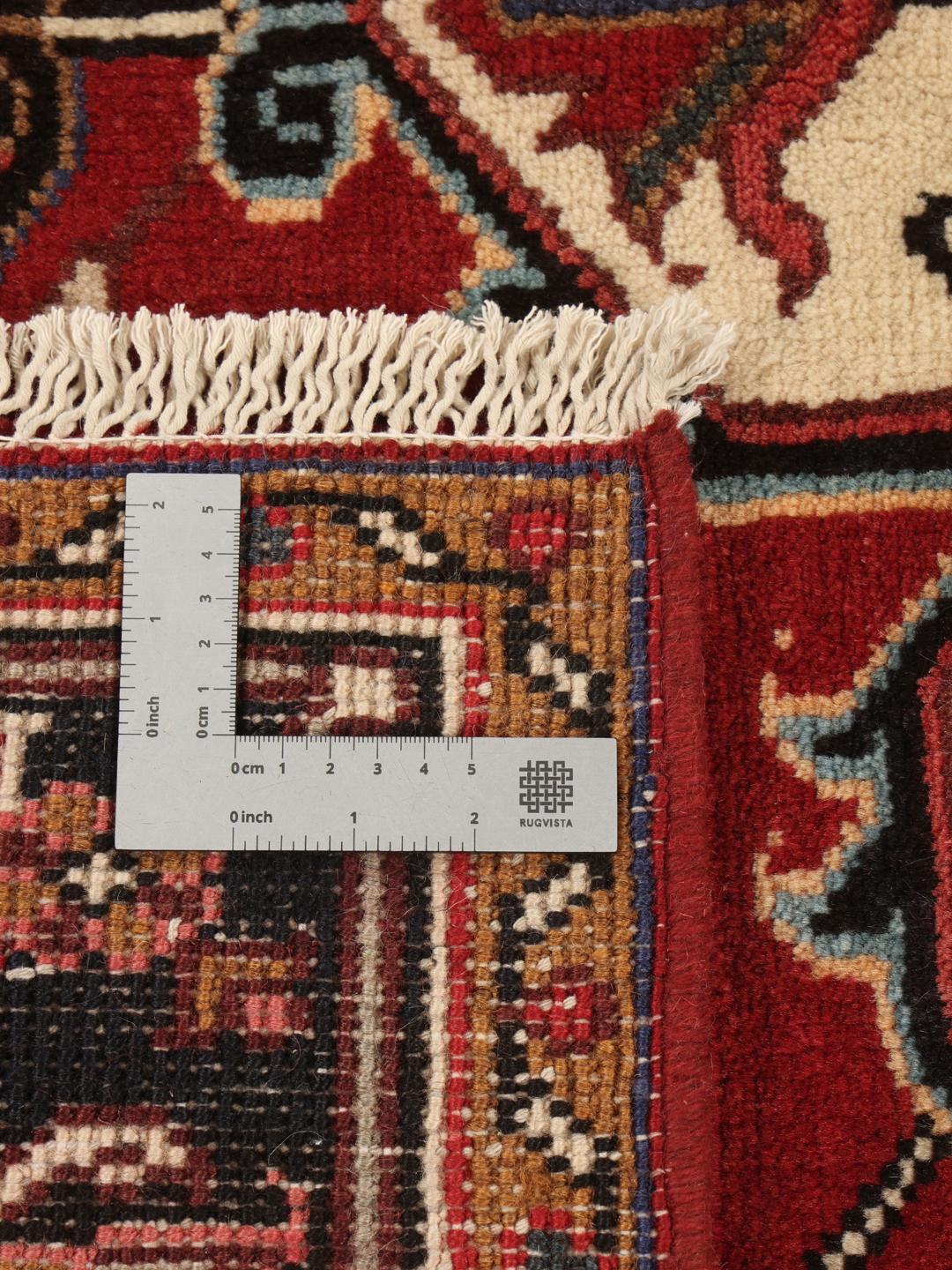 Tapis Mehraban noué à la main provenant du Moyen-Orient, présentant un champ rouge et un médaillon crème.