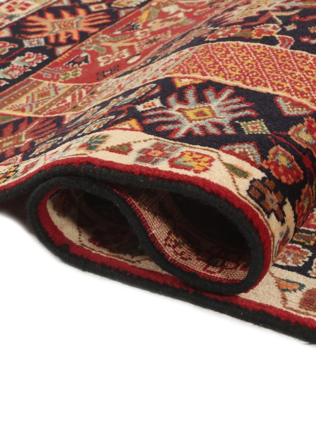A hand-knotted Qashqai runner featuring traditional tribal motifs in deep red and navy blue.