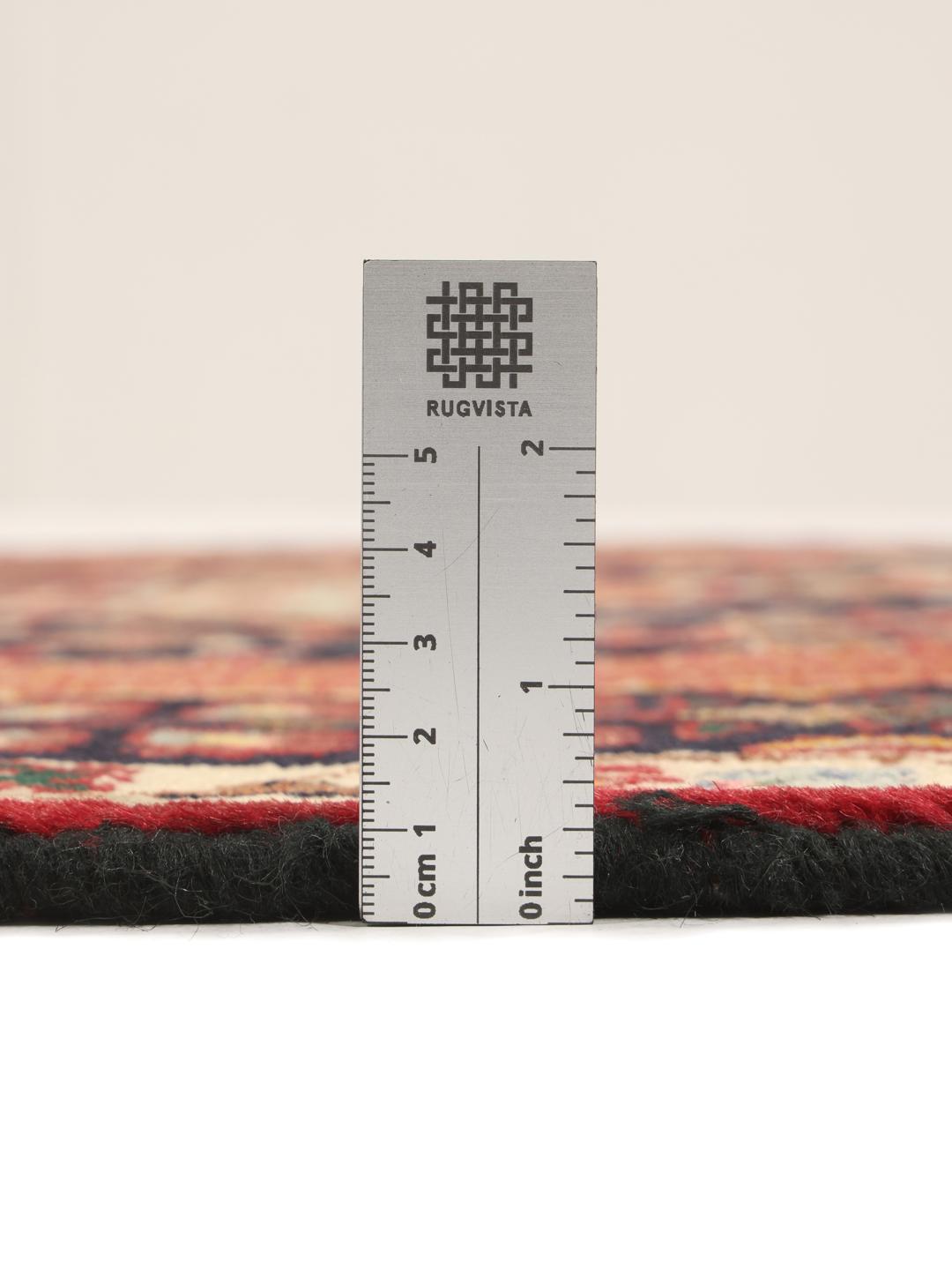 A hand-knotted Qashqai runner featuring traditional tribal motifs in deep red and navy blue.