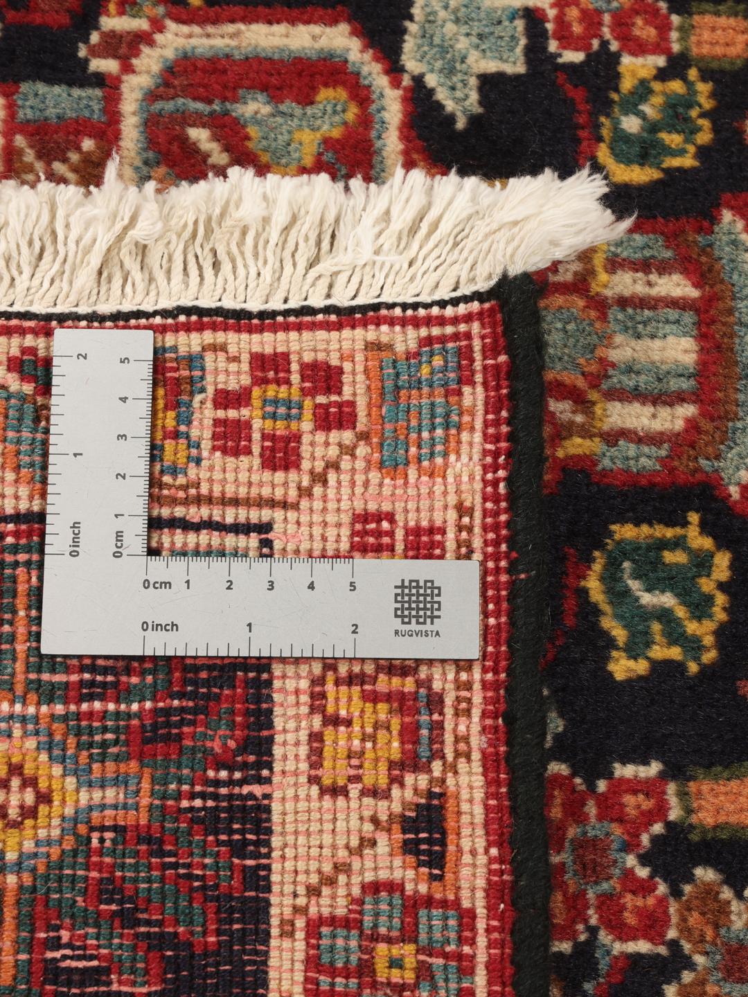 A hand-knotted Qashqai runner featuring traditional tribal motifs in deep red and navy blue.