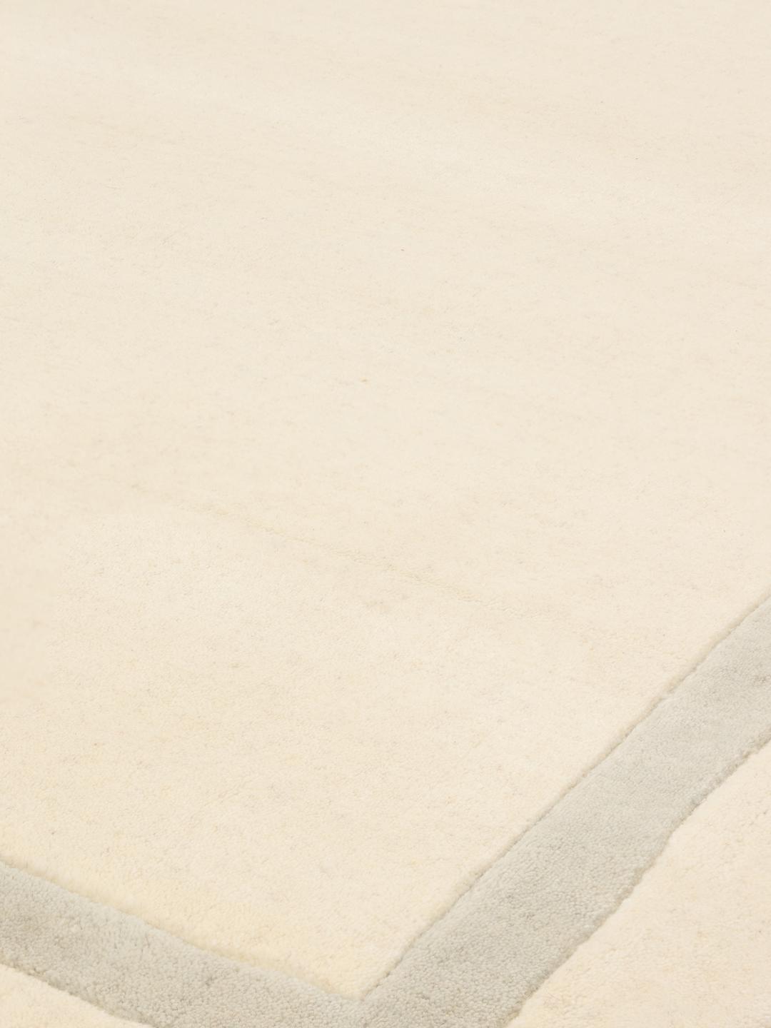 Tapis tissé à la main originaire d'Inde dans une couleur beige neutre avec une bordure subtile