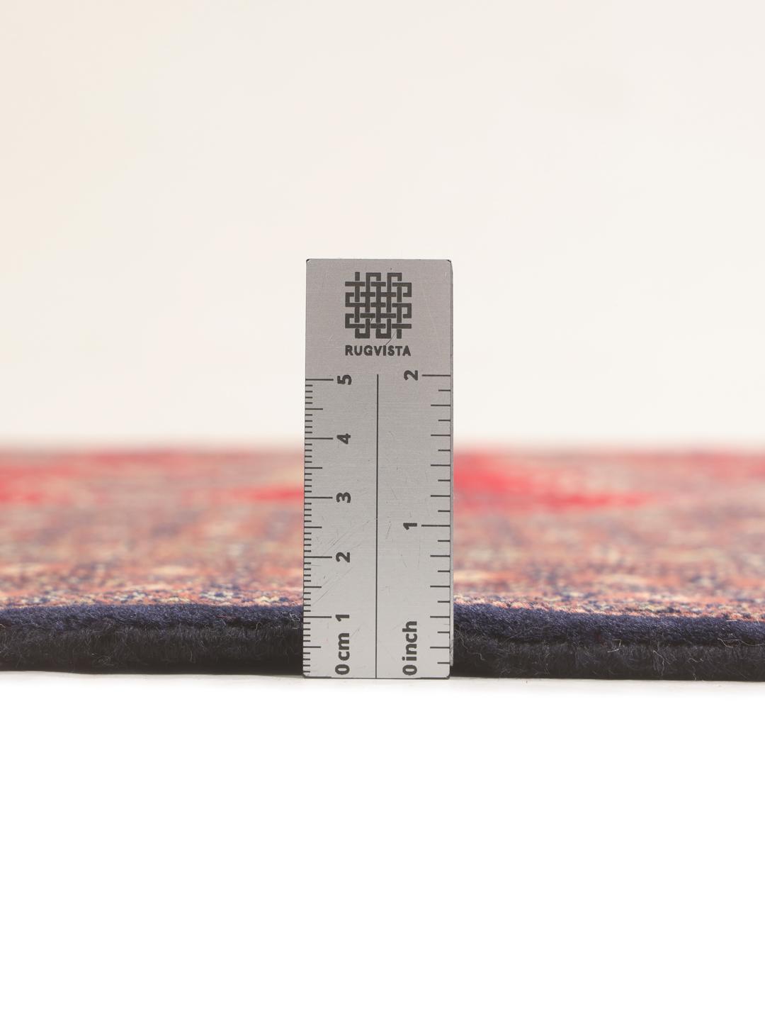 Et stort rektangulært Pakistan Bokhara tæppe med et rødt felt og gentagne geometriske motiver.