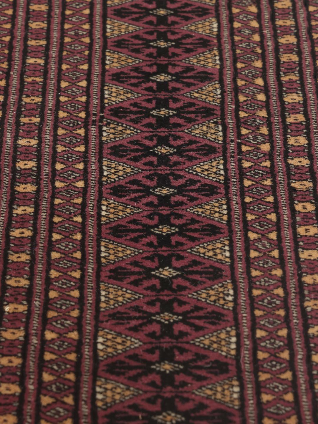 Et håndknyttet Pakistan Bokhara-tæppe med en dyb rød bund og traditionelle geometriske motiver