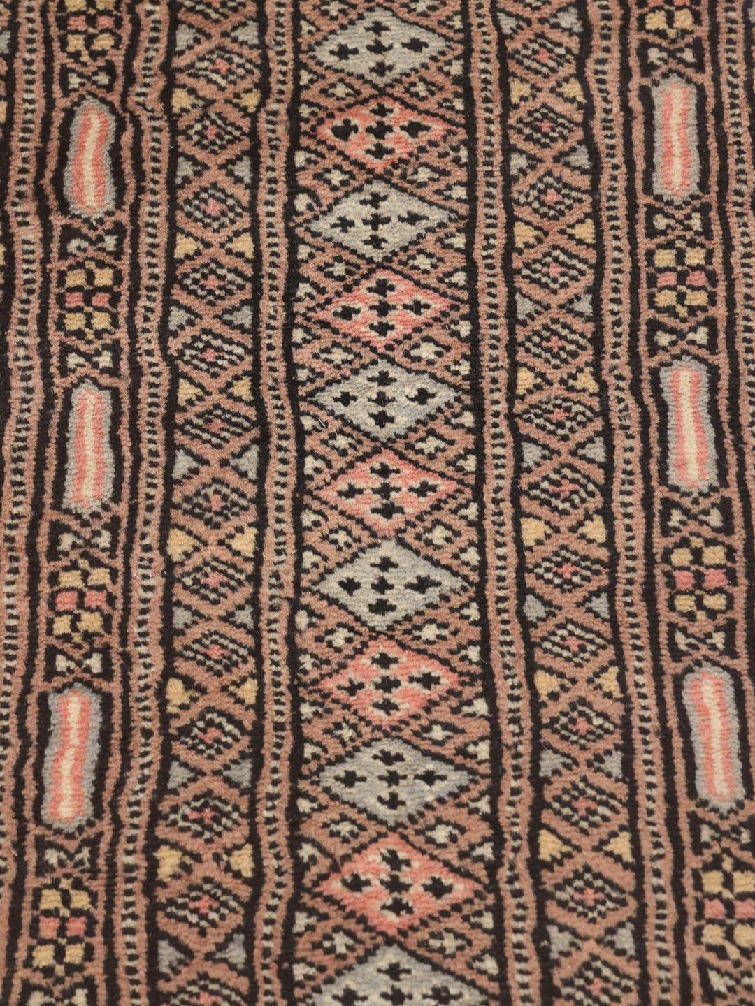 A large hand-knotted Pakistan Bokhara 2ply rug in pink with geometric patterns.