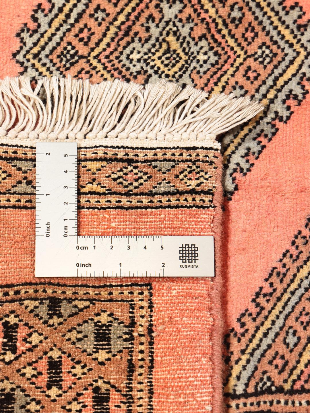 A large hand-knotted Pakistan Bokhara 2ply rug in pink with geometric patterns.