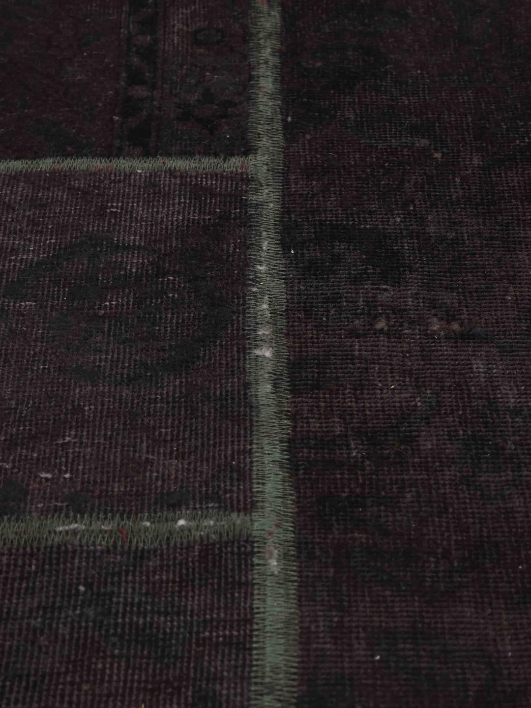 Et kvadratisk sort patchwork-tæppe med et moderne geometrisk design fra Mellemøsten