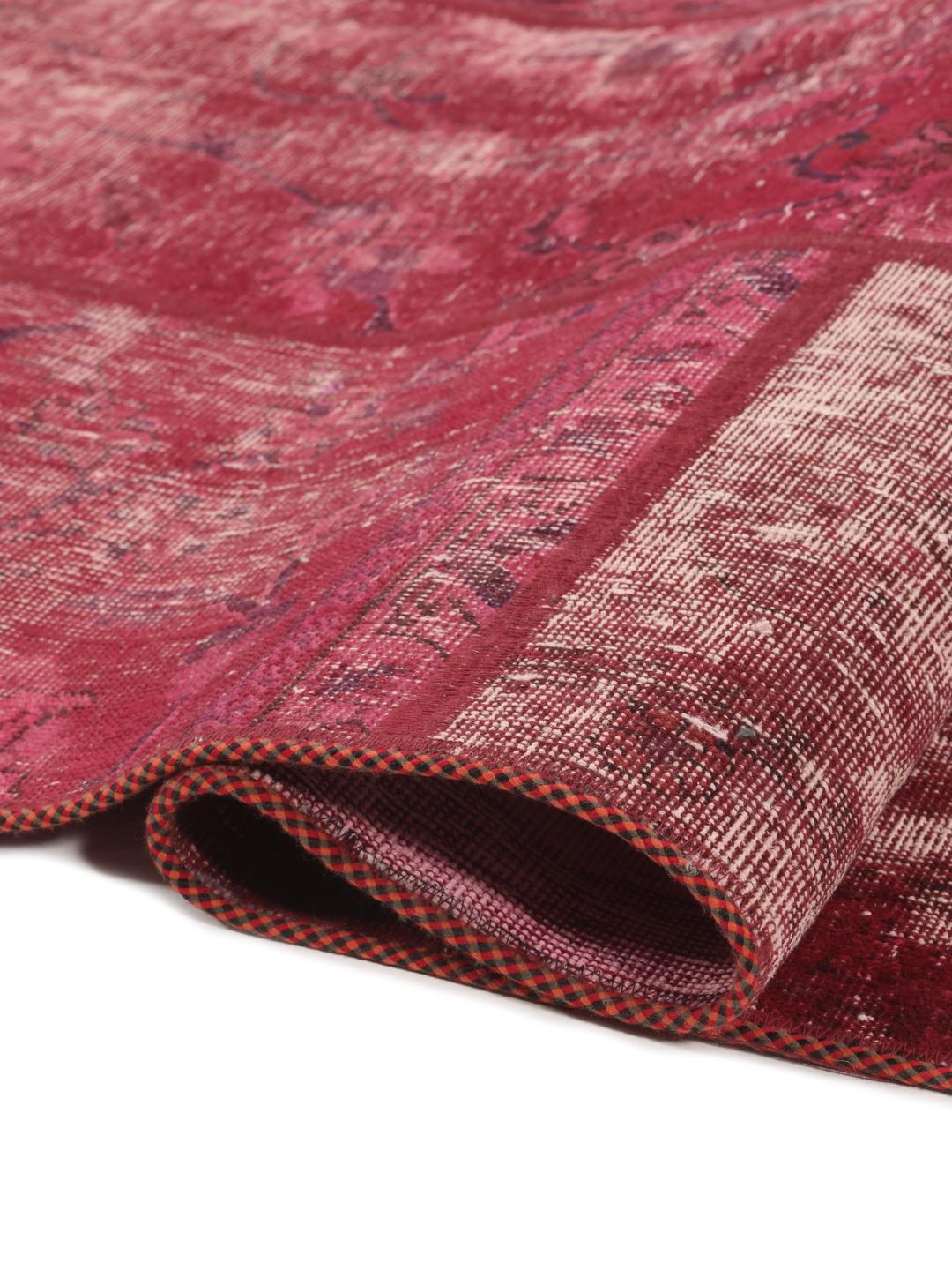 A vibrant patchwork rug from the Middle East featuring diverse shades of dark-red.