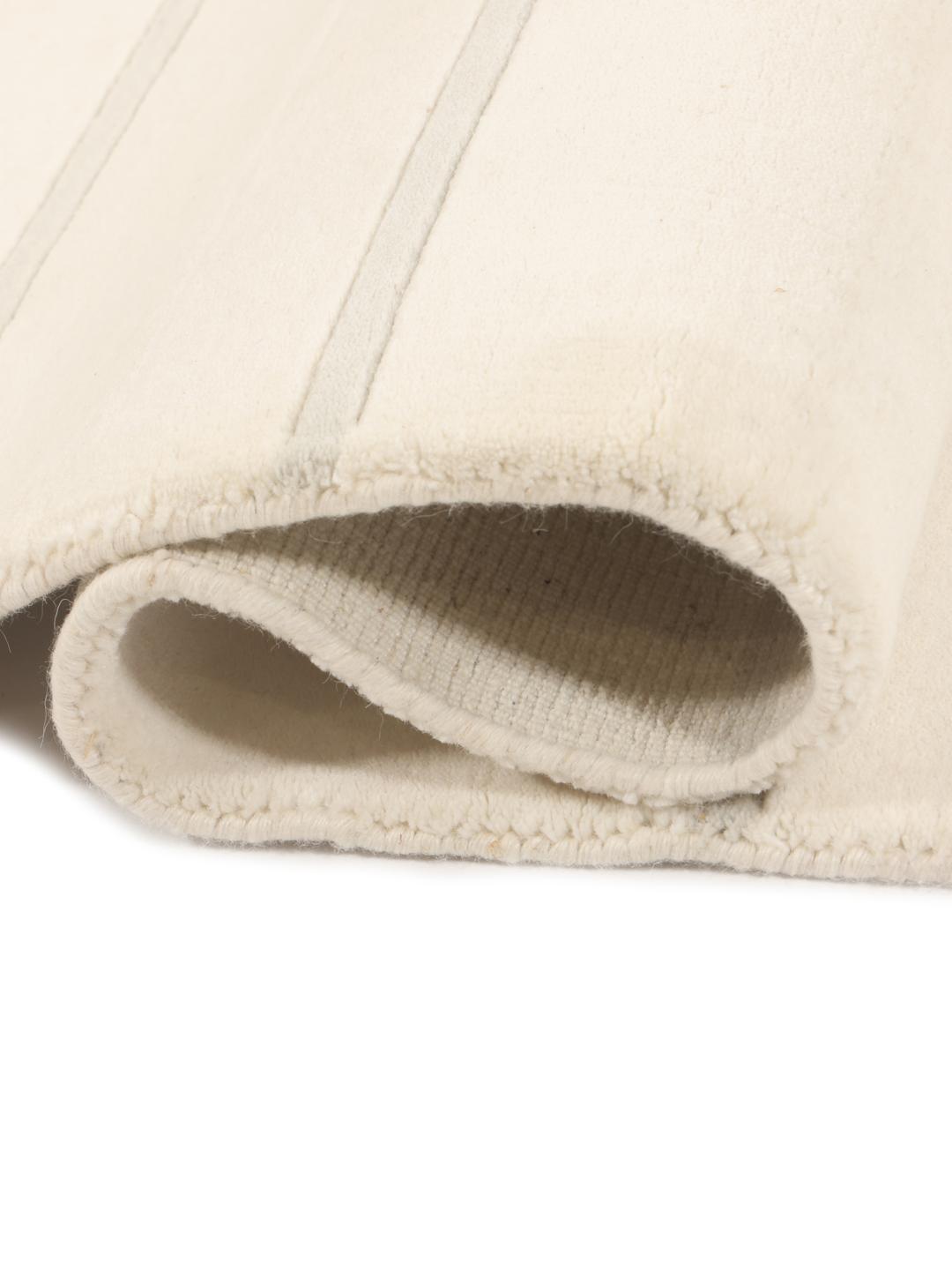 Moderne minimalistisk tæppe med rene linjer i beige, fremstillet i Indien.