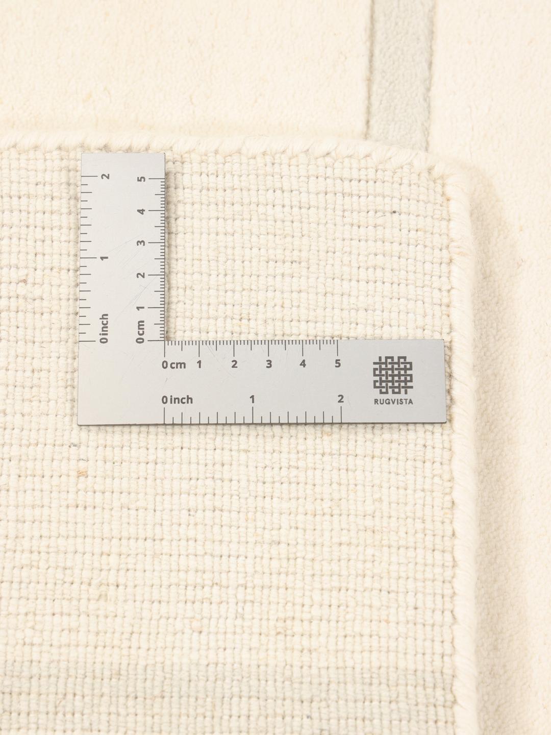Moderne minimalistisk tæppe med rene linjer i beige, fremstillet i Indien.