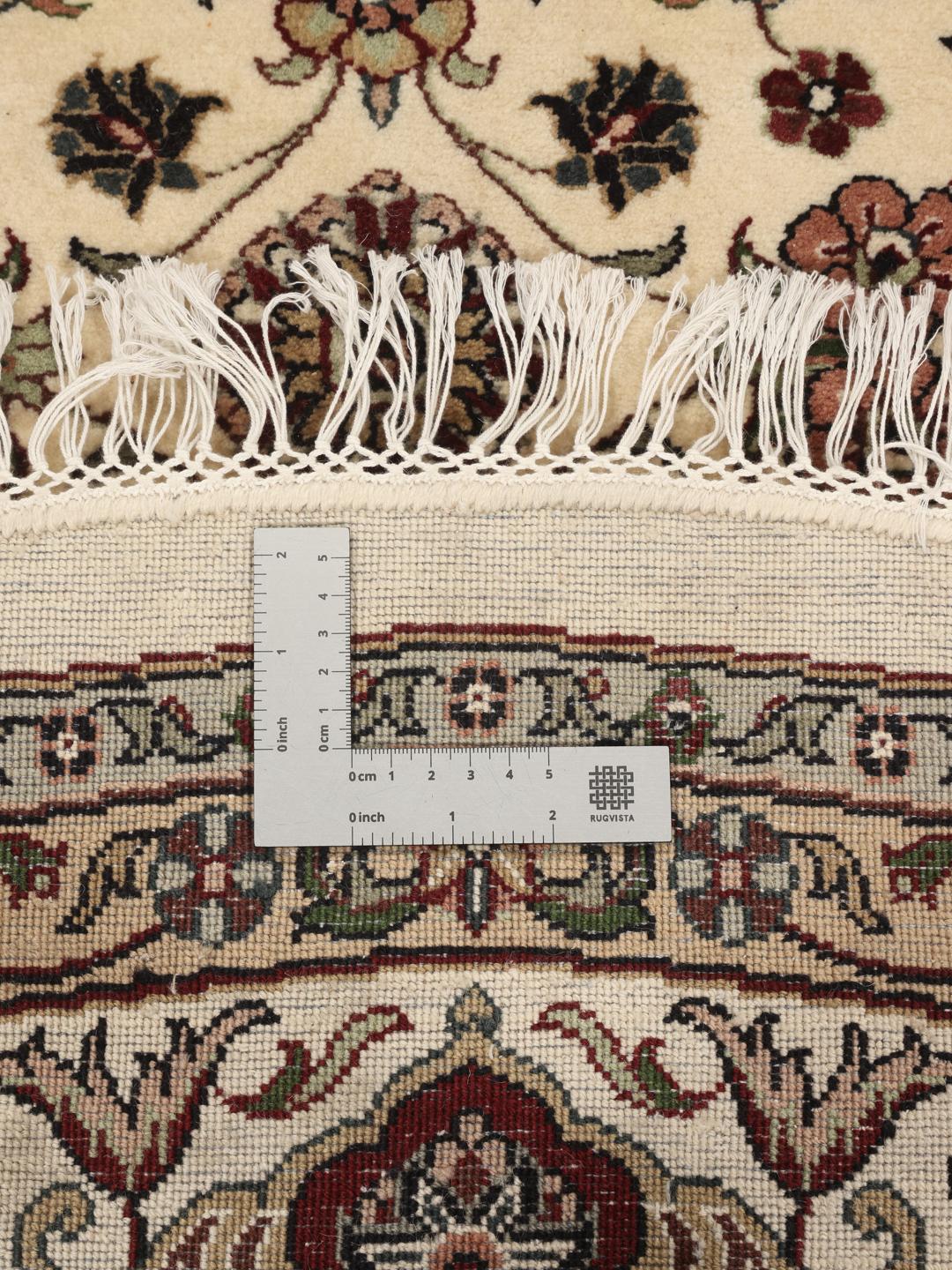 Tapis Sarough rond avec motif floral, noué à la main en Inde dans des tons beige.
