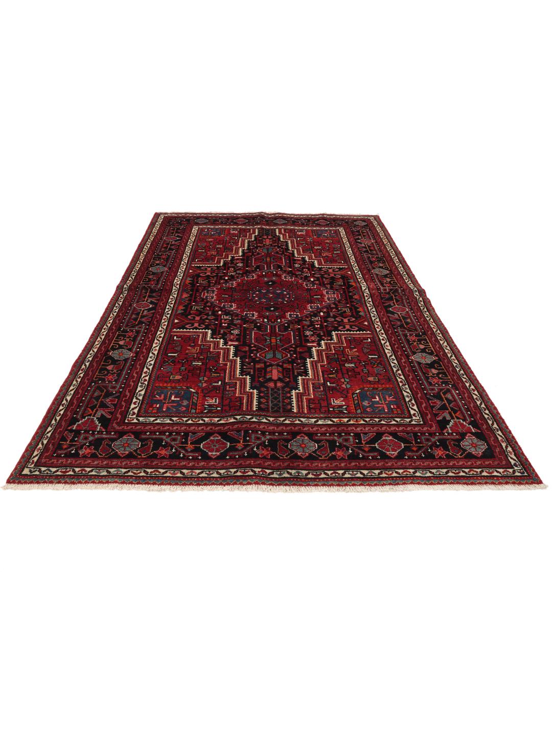 A hand-knotted Toiserkan rug from the Middle East featuring a dark-red and black geometric medallion design.