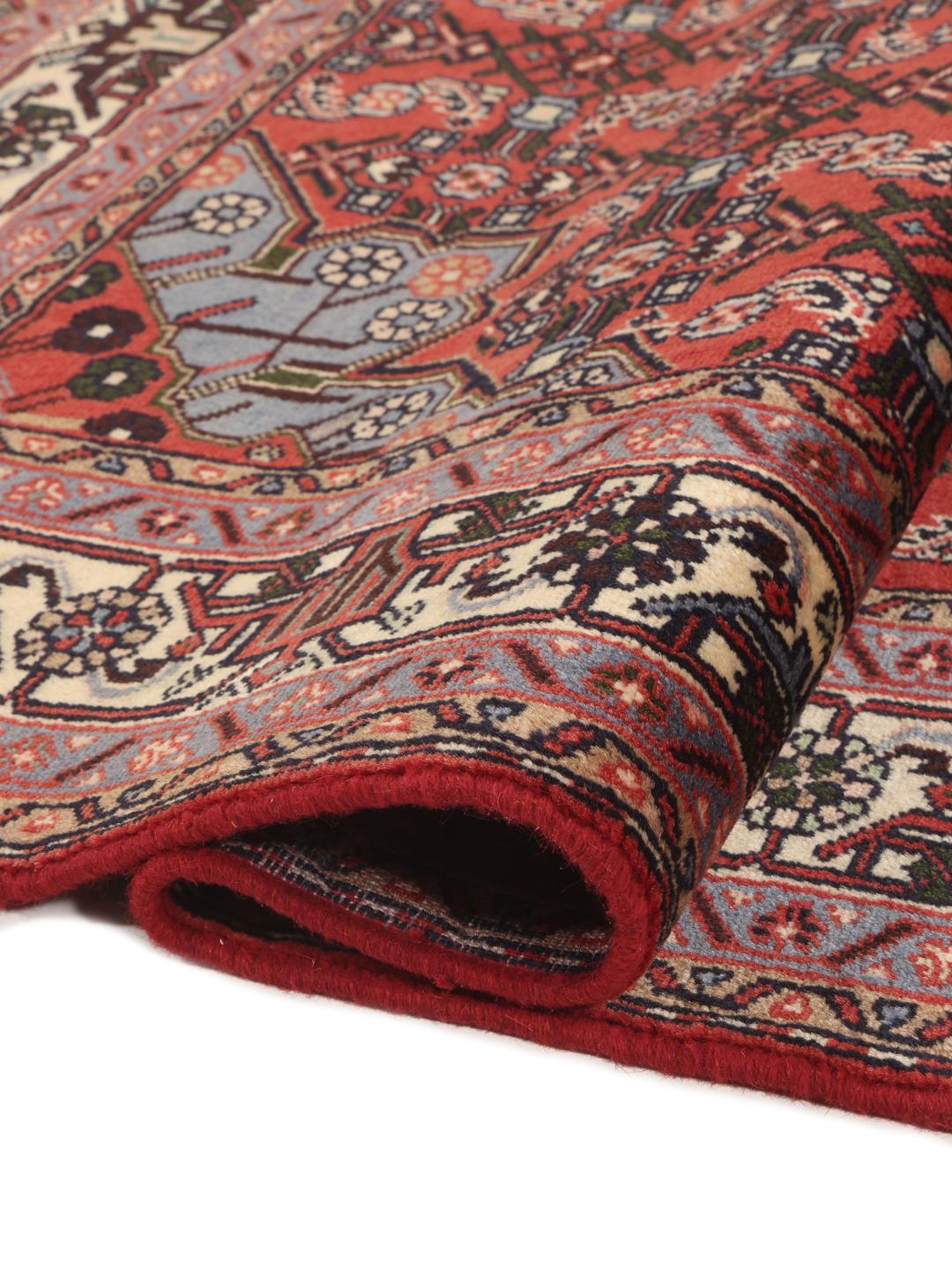 A hand-knotted Hamadan rug from the Middle East with a red field and intricate patterns.