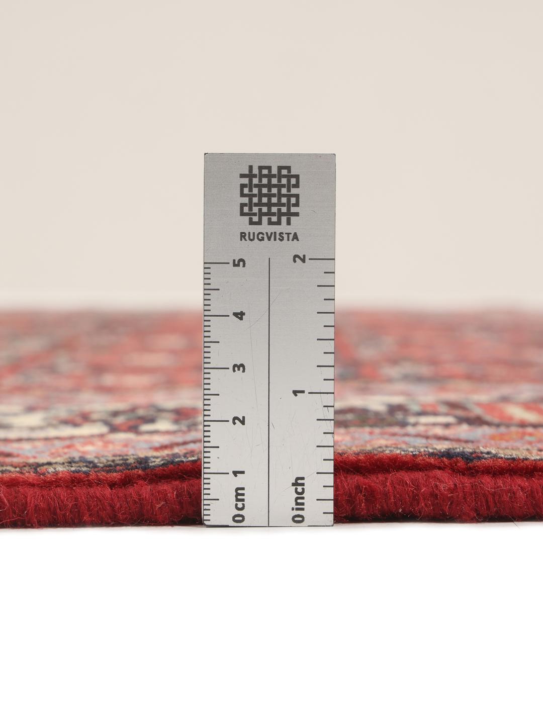 A hand-knotted Hamadan rug from the Middle East with a red field and intricate patterns.