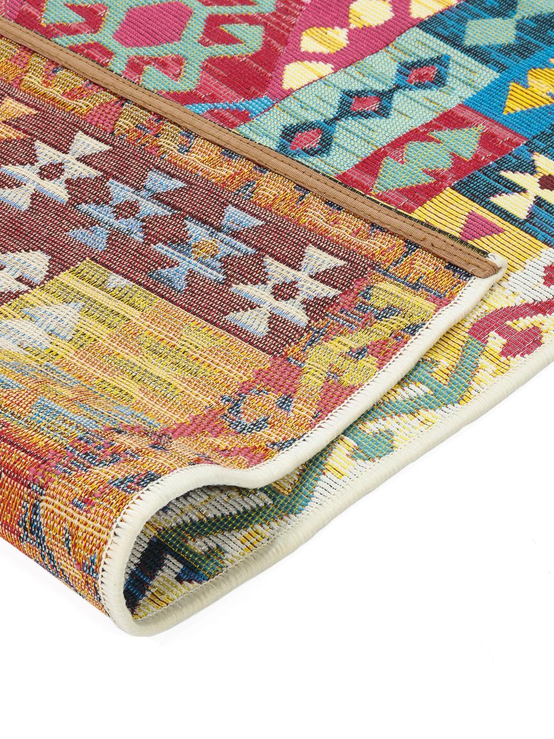 Flerfarvet tæppe med et geometrisk kilim-mønster.
