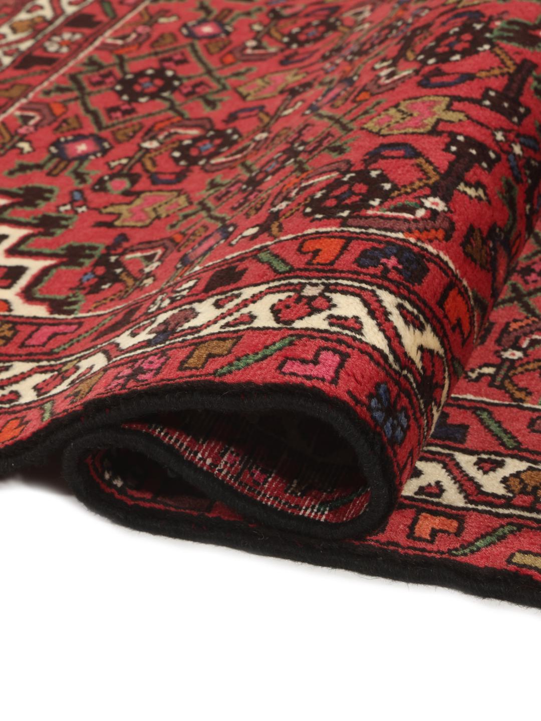 Tapis Hosseinabad noué main en provenance du Moyen-Orient, dans des tons rouge profond avec des motifs géométriques.