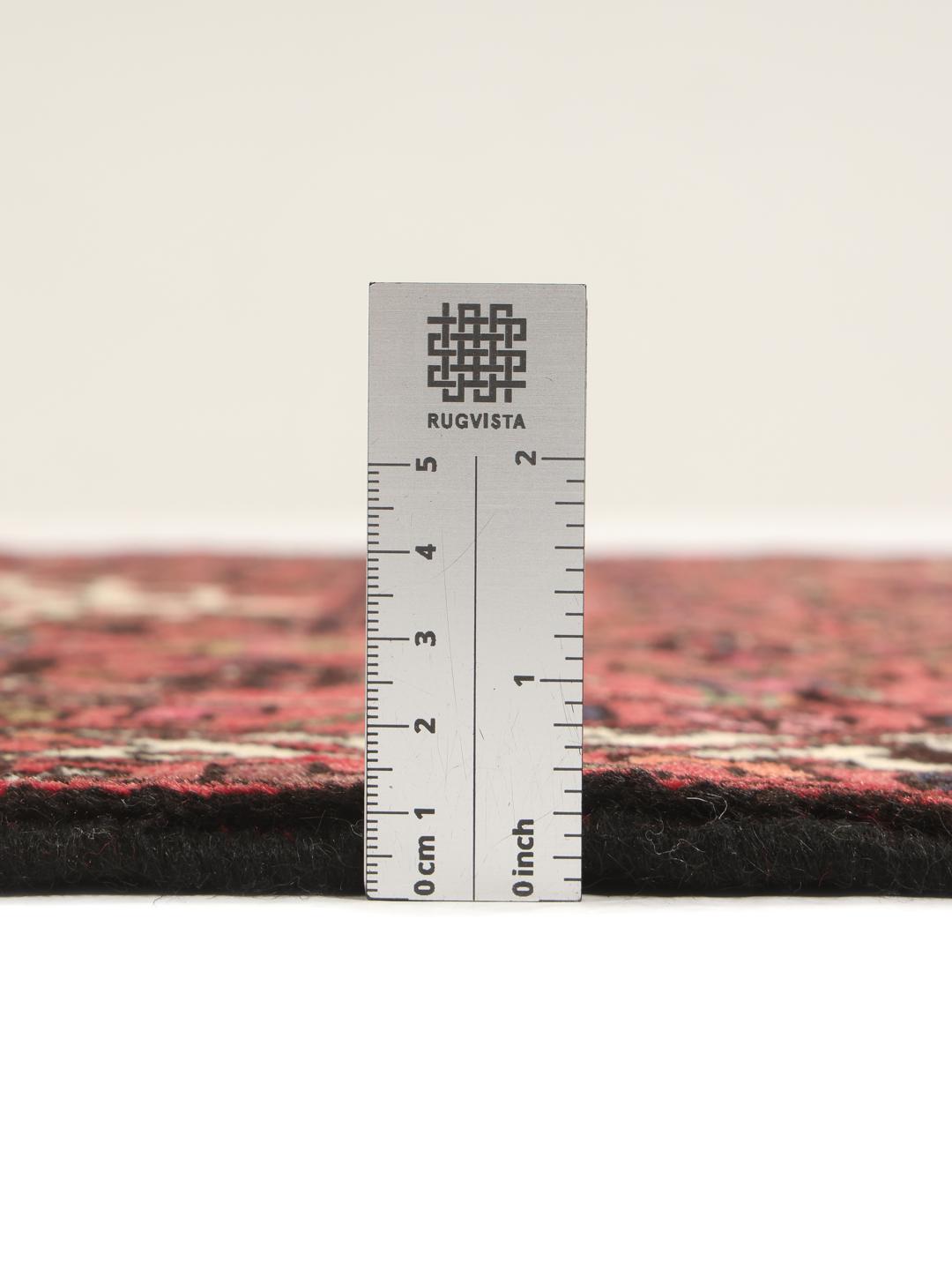 Tapis Hosseinabad noué main en provenance du Moyen-Orient, dans des tons rouge profond avec des motifs géométriques.