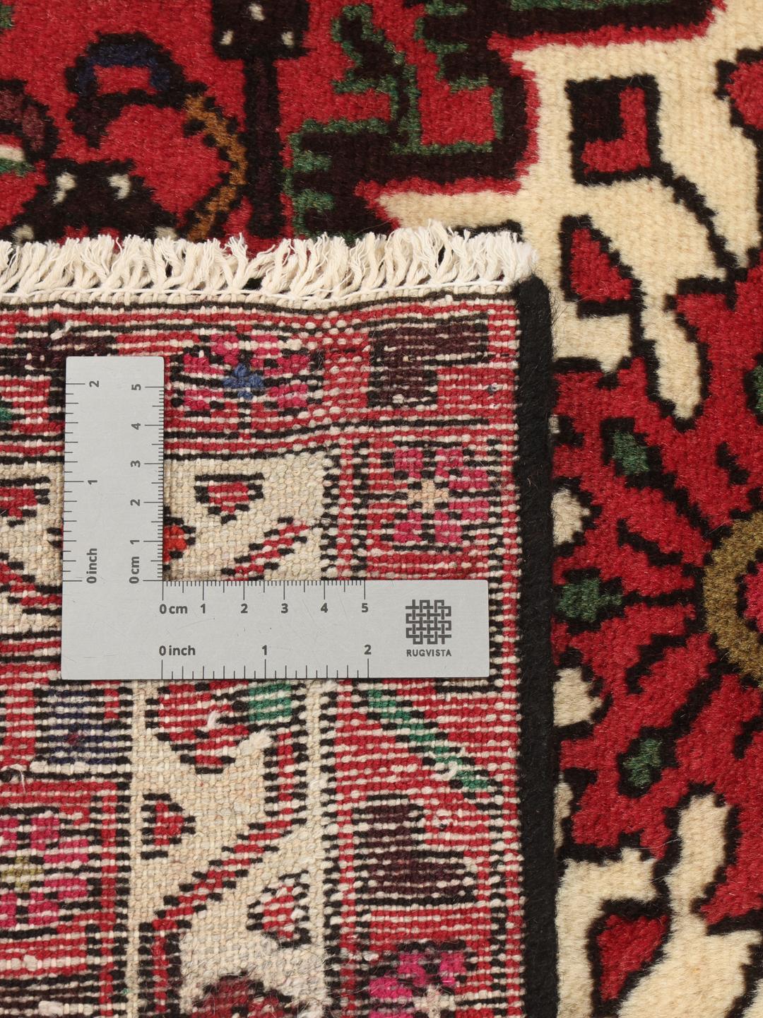 Tapis Hosseinabad noué main en provenance du Moyen-Orient, dans des tons rouge profond avec des motifs géométriques.