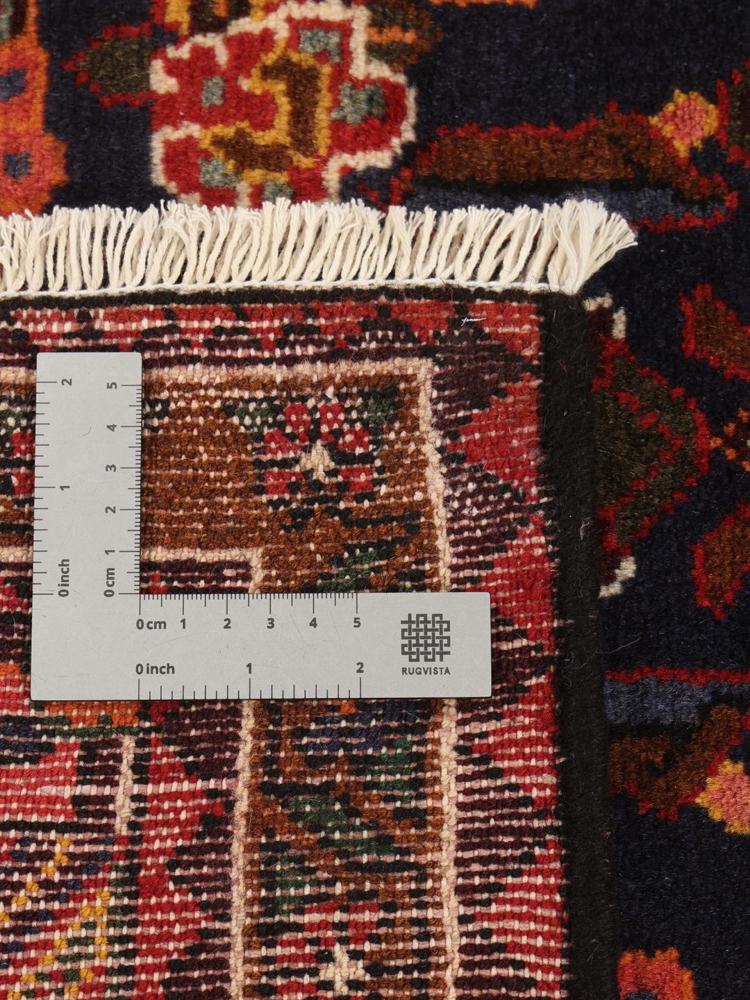 Handgeknoopt Saveh-tapijt uit het Midden-Oosten met een rood en blauw medaillonpatroon op een crèmekleurige achtergrond.