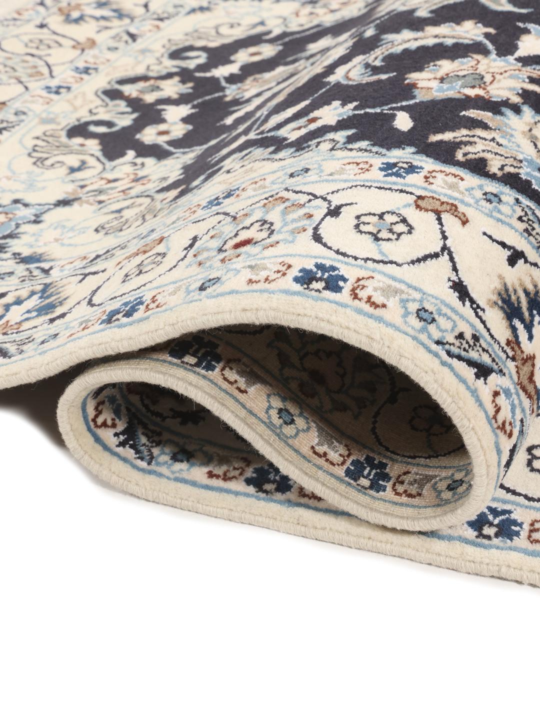 A hand-knotted Nain rug from the Middle East featuring a black field and floral medallion in beige and blue tones.
