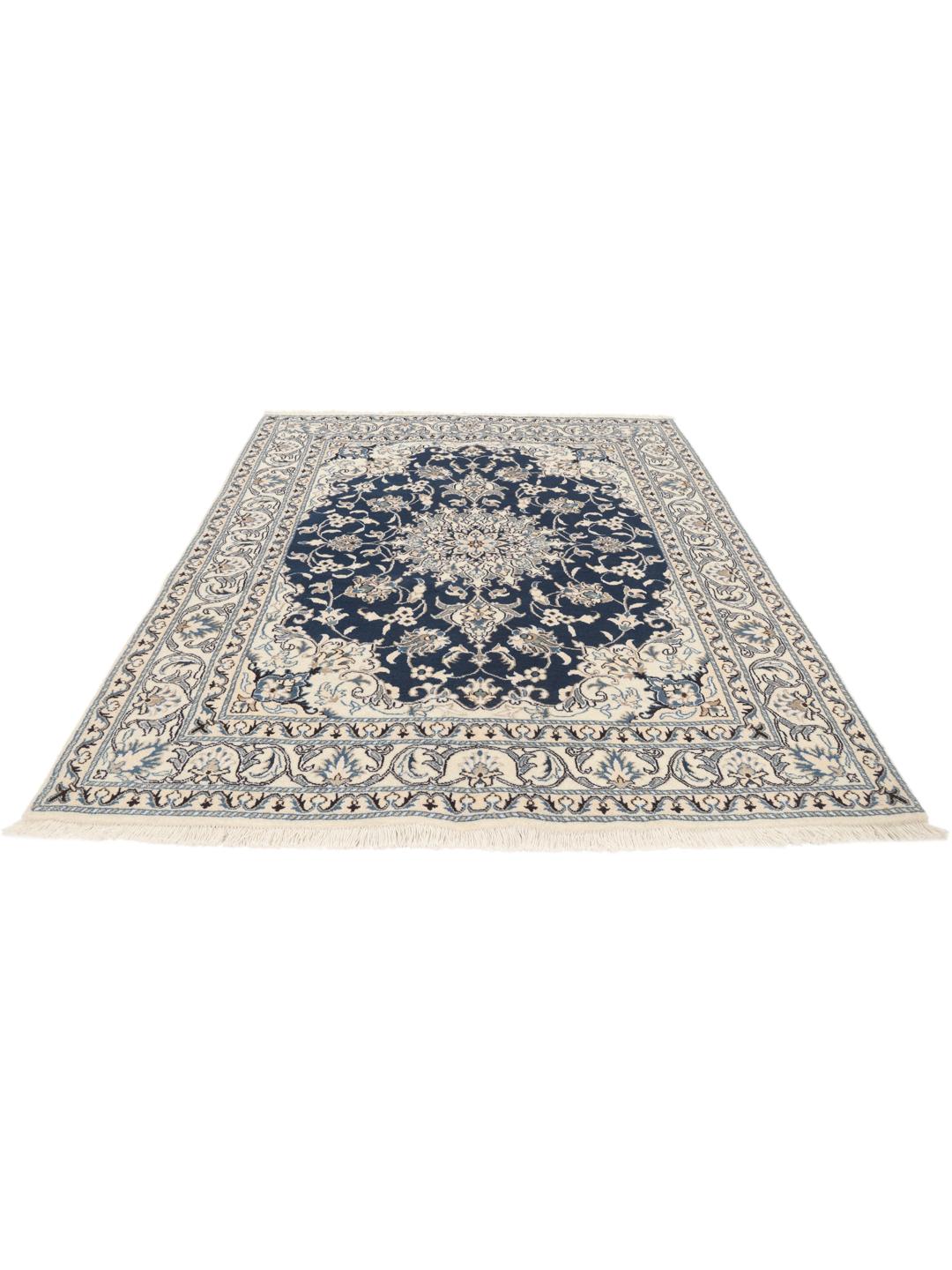 A hand-knotted Nain rug from the Middle East featuring a blue field with ivory floral patterns.