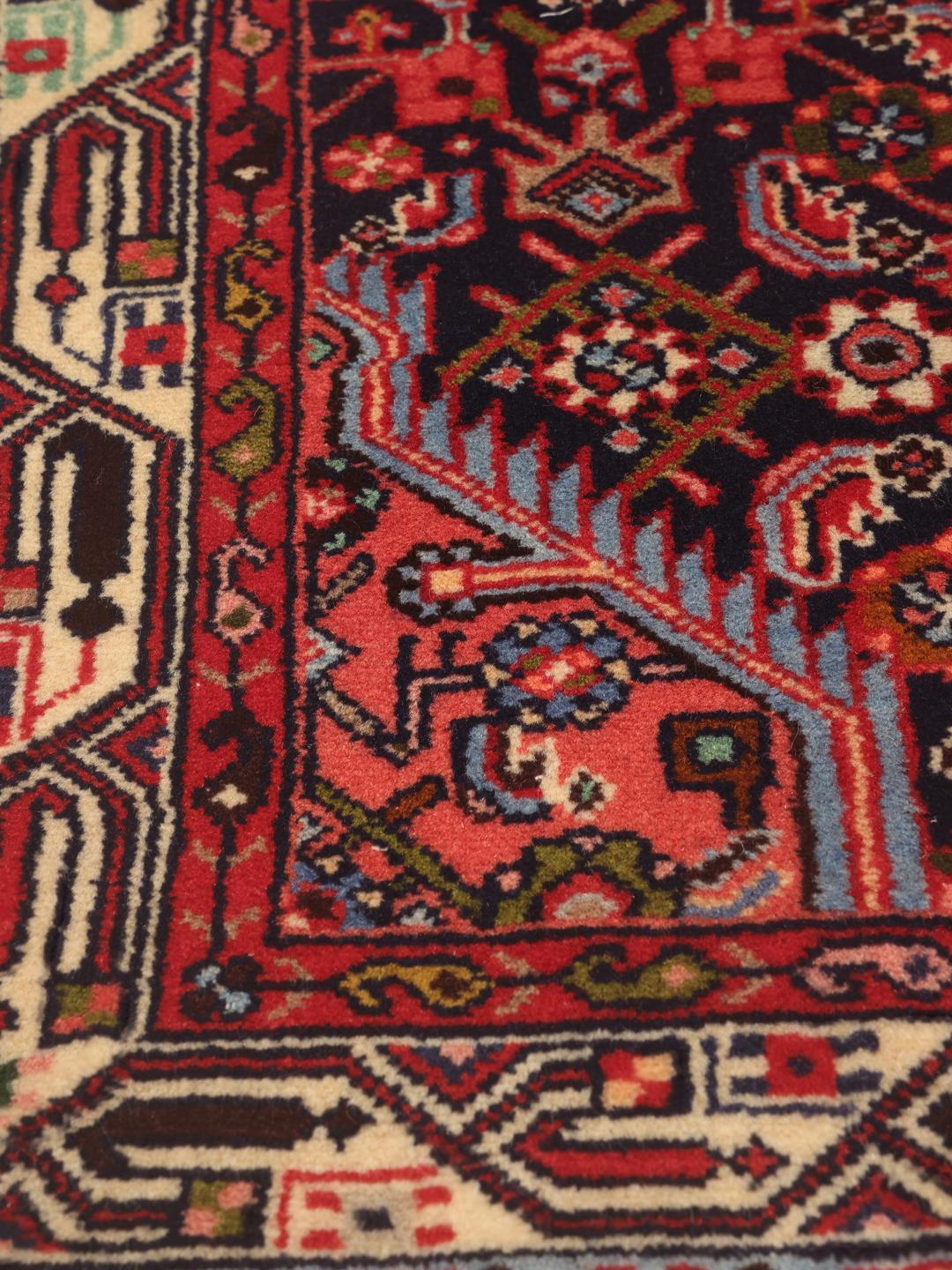Hand-knotted Asadabad runner with intricate geometric patterns in dark red and blue tones