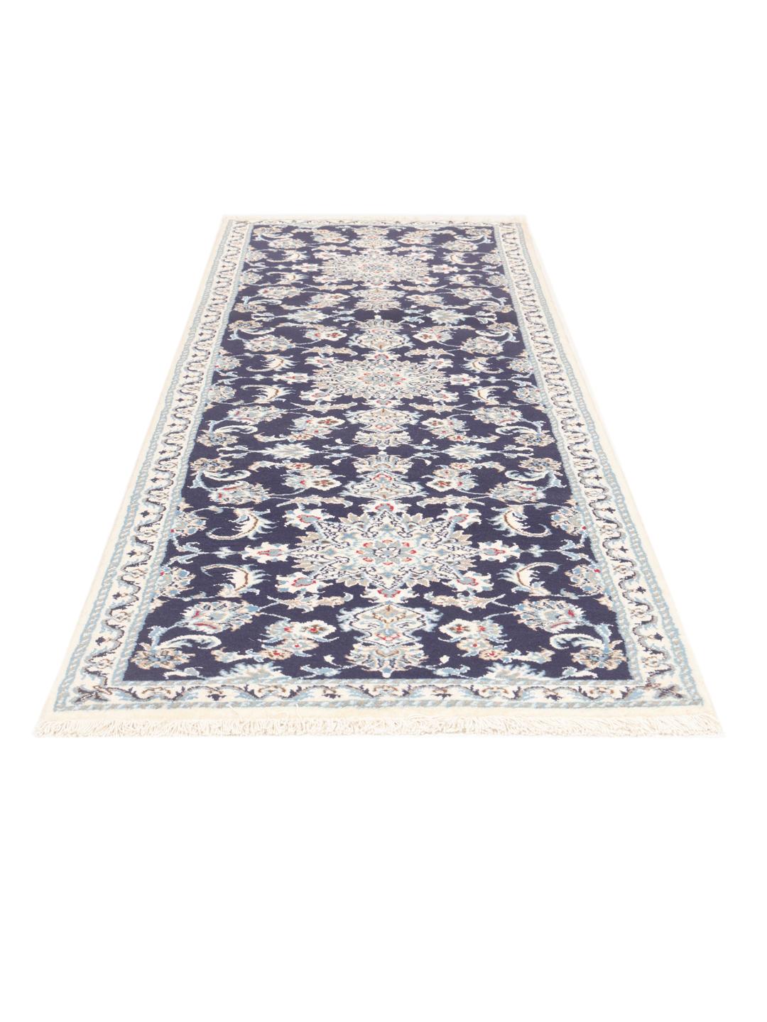A hand-knotted Nain runner from the Middle East in dark blue with floral patterns.