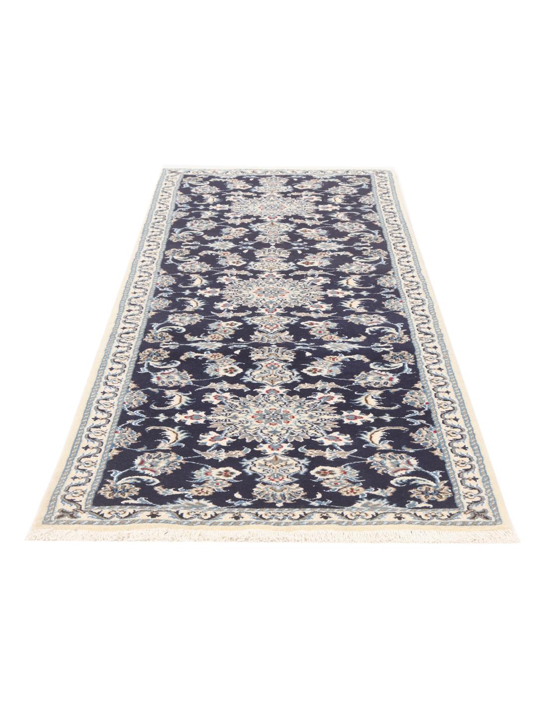 A hand-knotted Nain runner from the Middle East in dark blue with floral patterns.